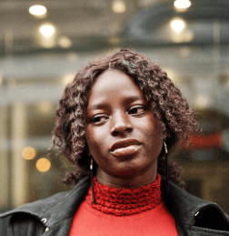 Nigerian woman in red representing vigilance, digital awareness, and online identity verification with Profiled Nigeria