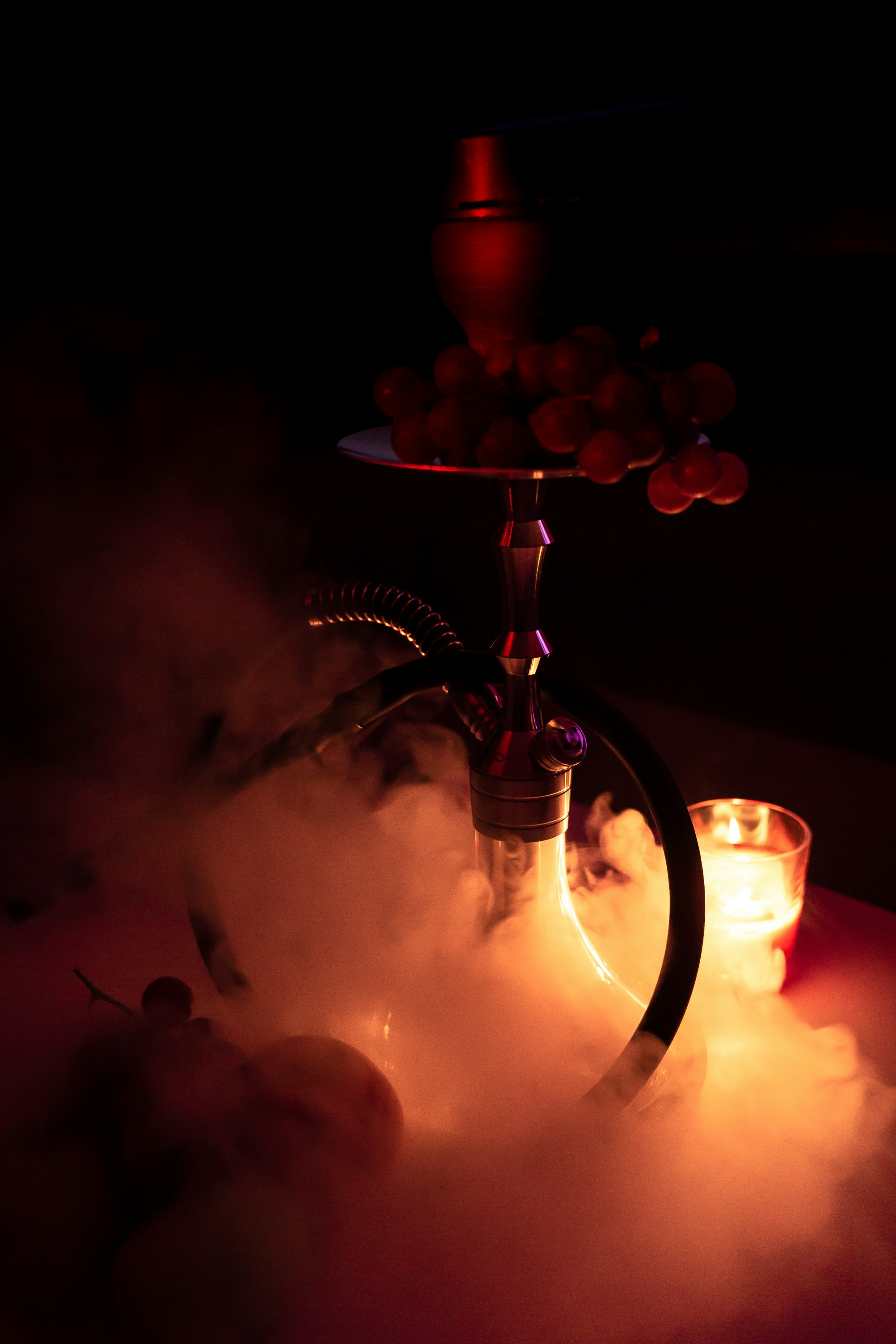 An image of a hookah with a candle and smoke