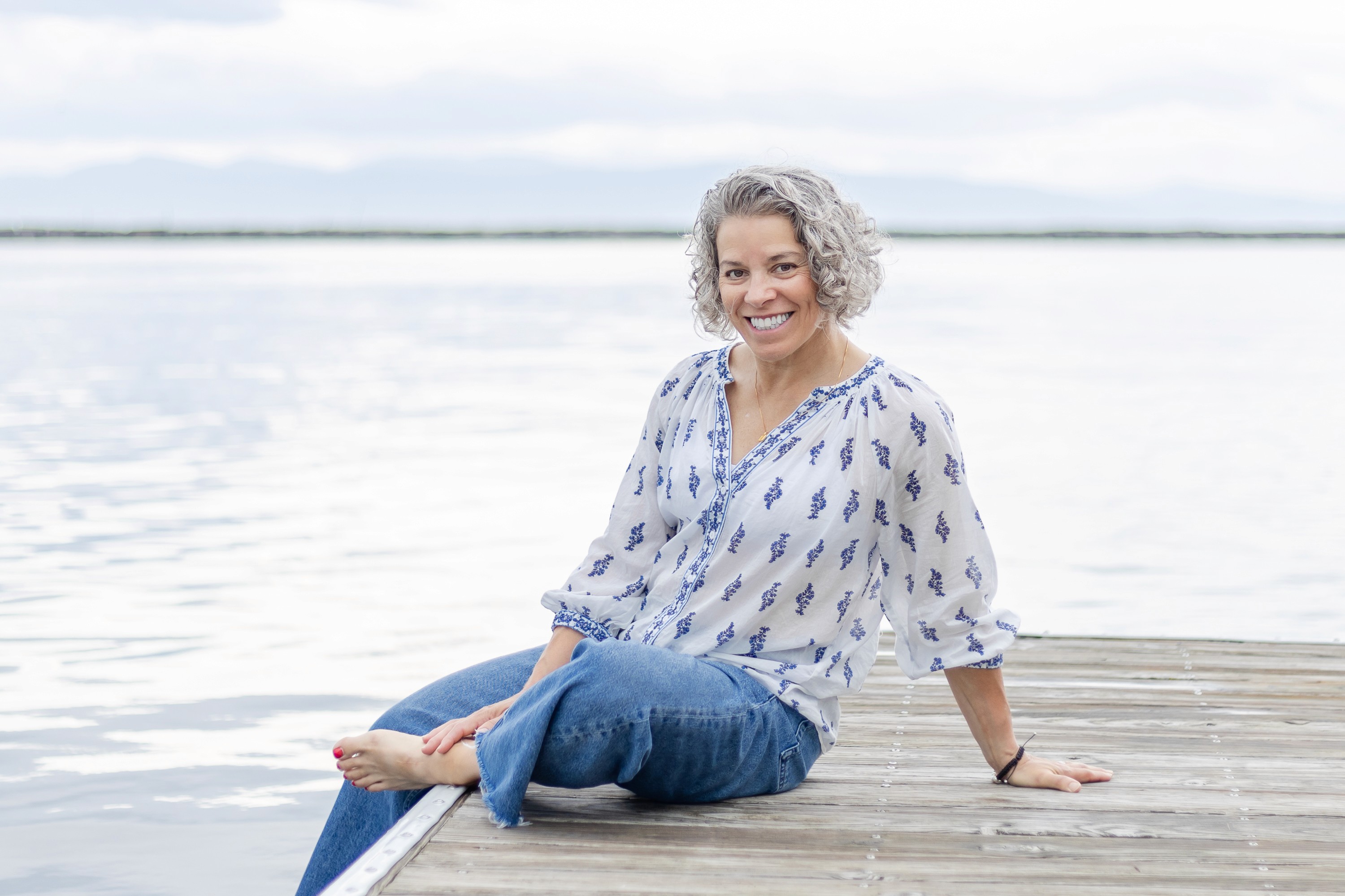 Headshot photo of Julie Roick sitting on a pier