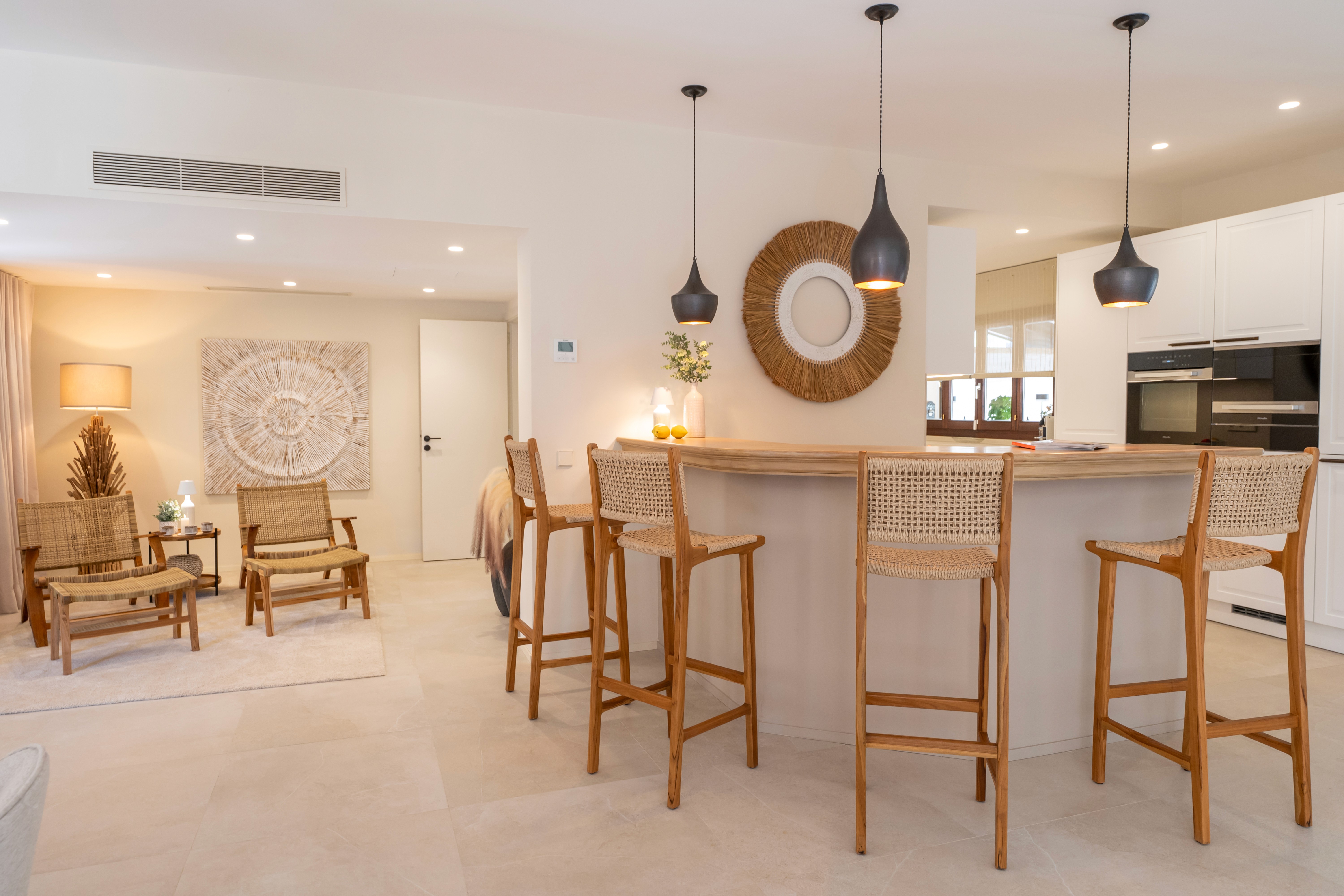 Küche der Finca in Llucmajor mit Kochinsel, Holzhockern und mediterranem Interior Design