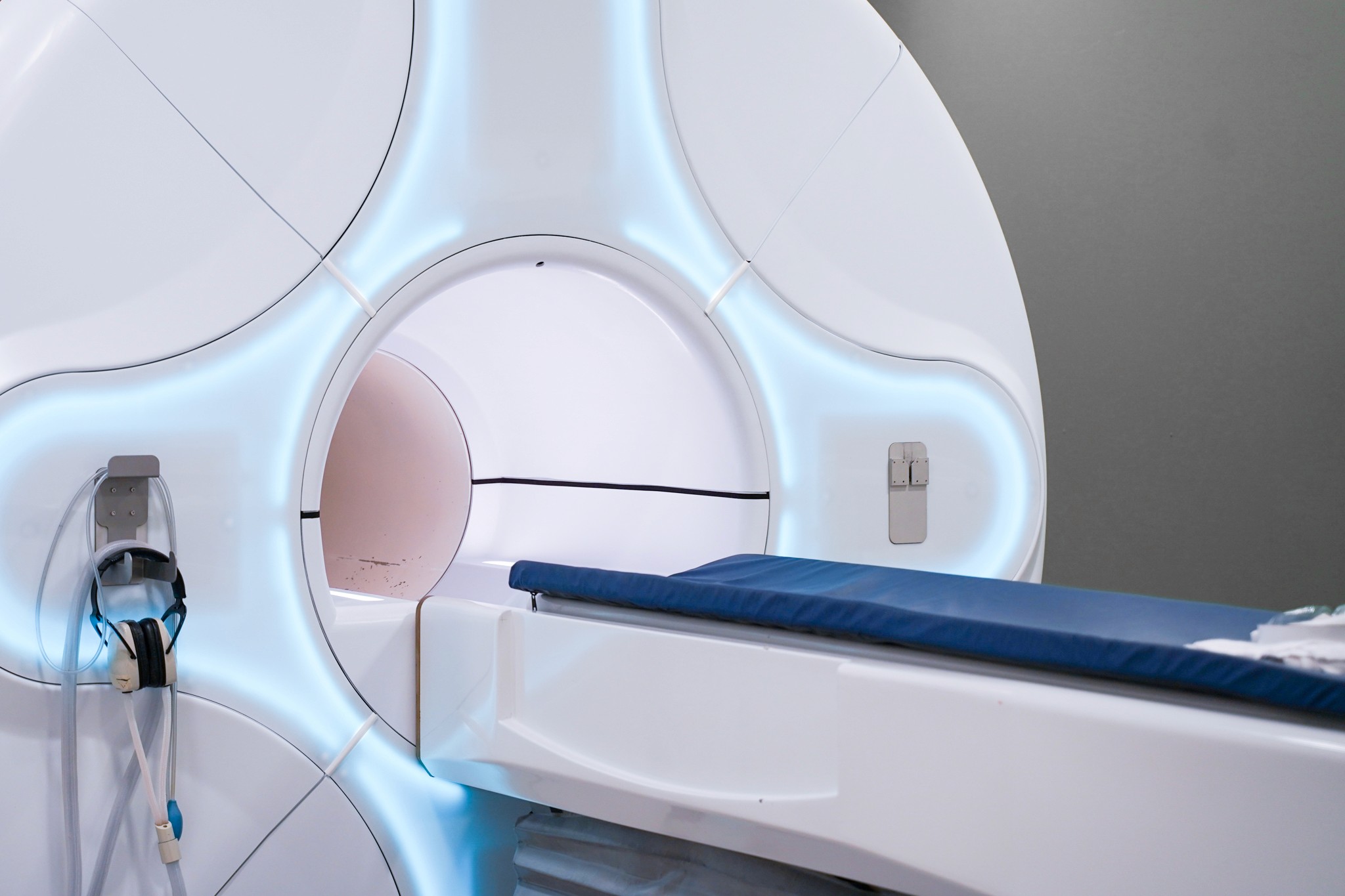 MRI MAchine with blue glowing lights around the entrance of it 