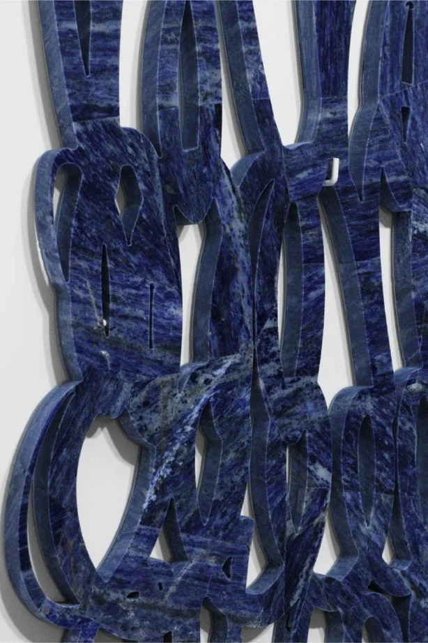 Scultura astratta in pietra blu con forme intrecciate, opera contemporanea iStone Arte che esplora geometrie fluide e texture naturali per valorizzare brand artistici