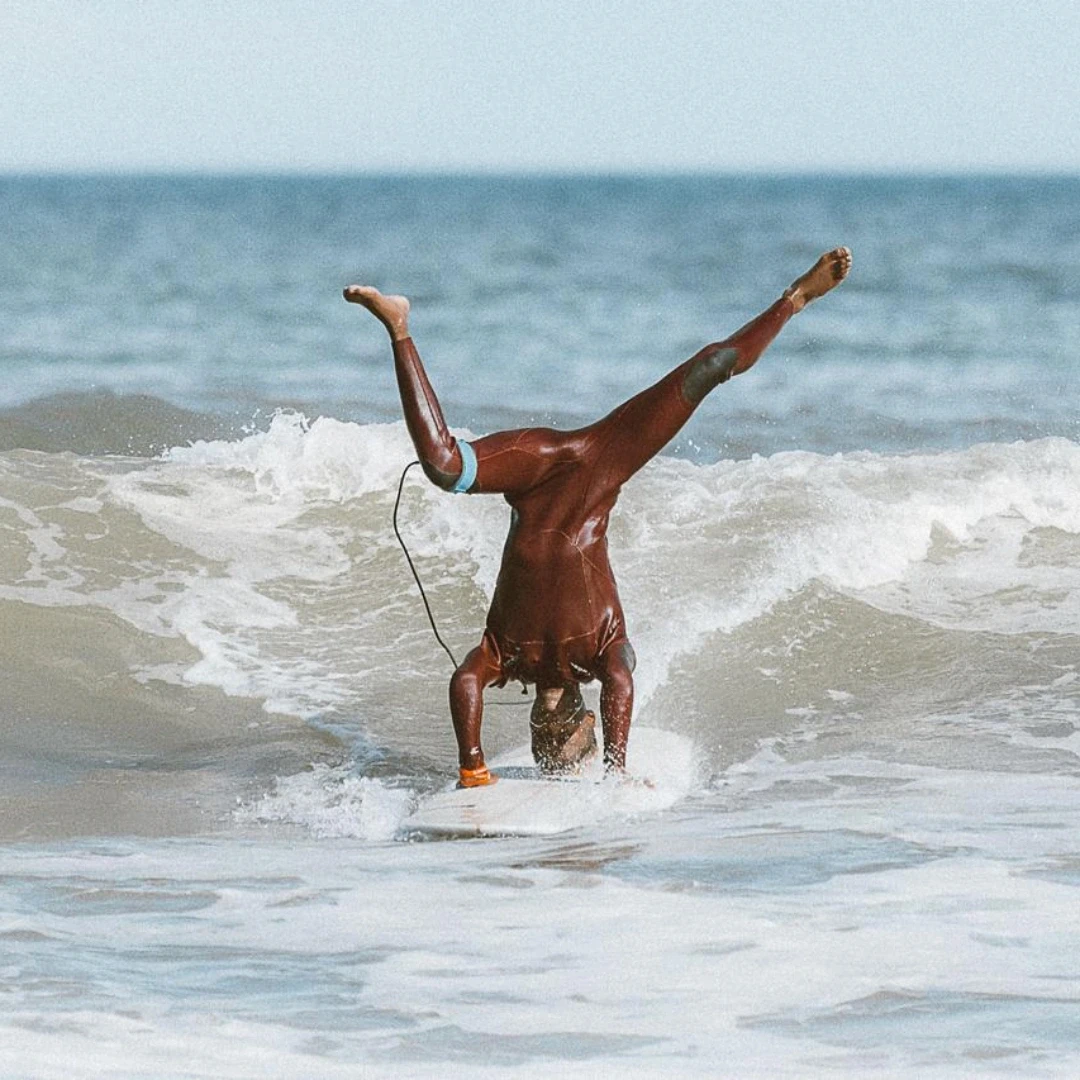 Coach Lonwabo doing a handstand while surfing