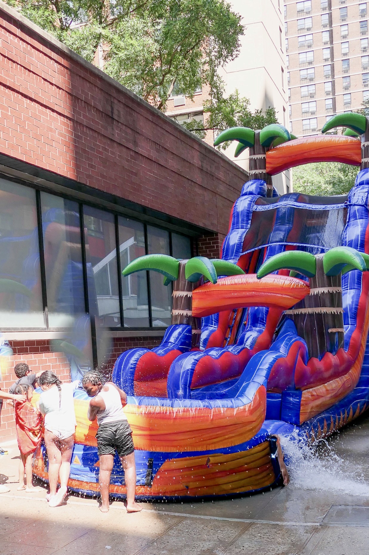 An image of kids playing with a water slide at Family Day at Rutgers Houses