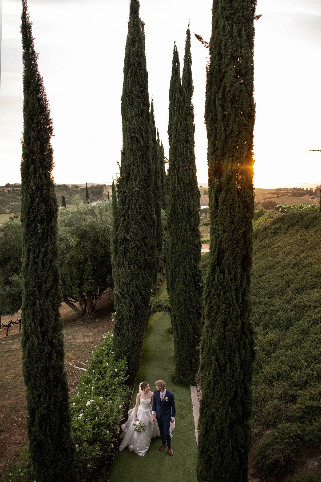 Elf woman in white dress raising hands by the river