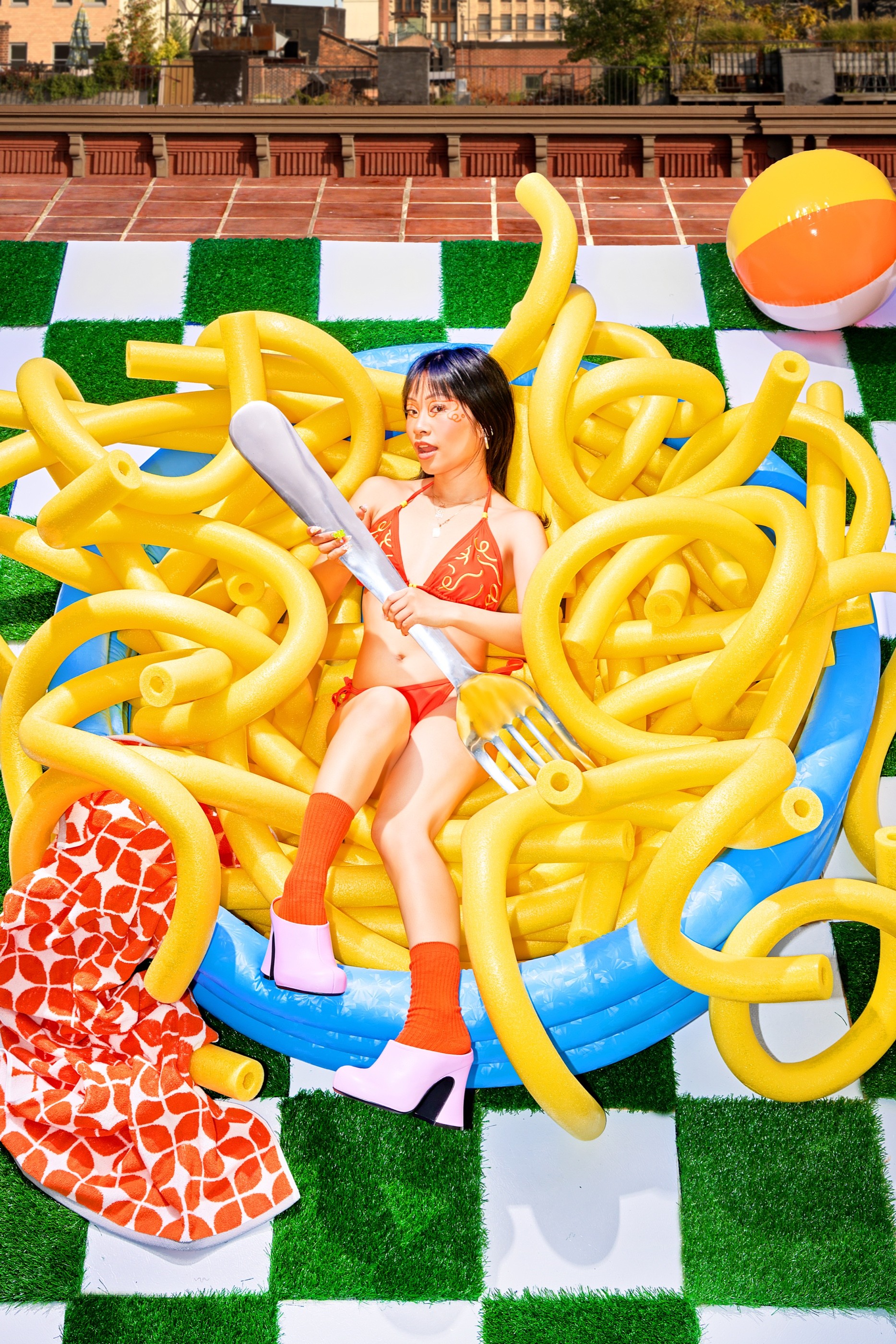 Yu Ling Wu holding an oversized fork on the colorful Banza Bucakini pool set