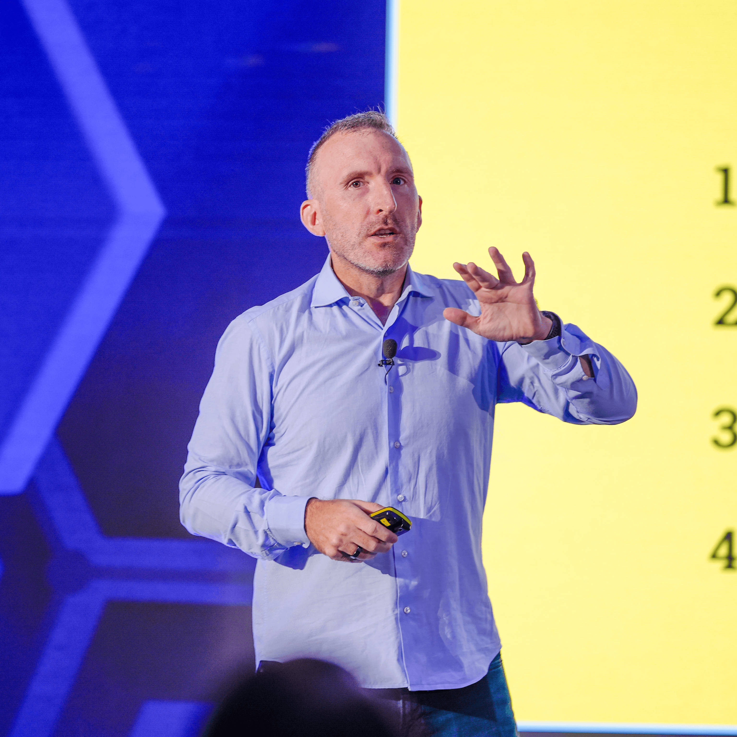 A 3D-rendered cluster of translucent pink and blue crystals growing from a textured rock base, illuminated by a warm glowing light on a neutral background.