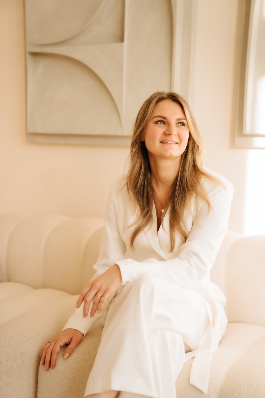 person writing on brown wooden table near white ceramic mug