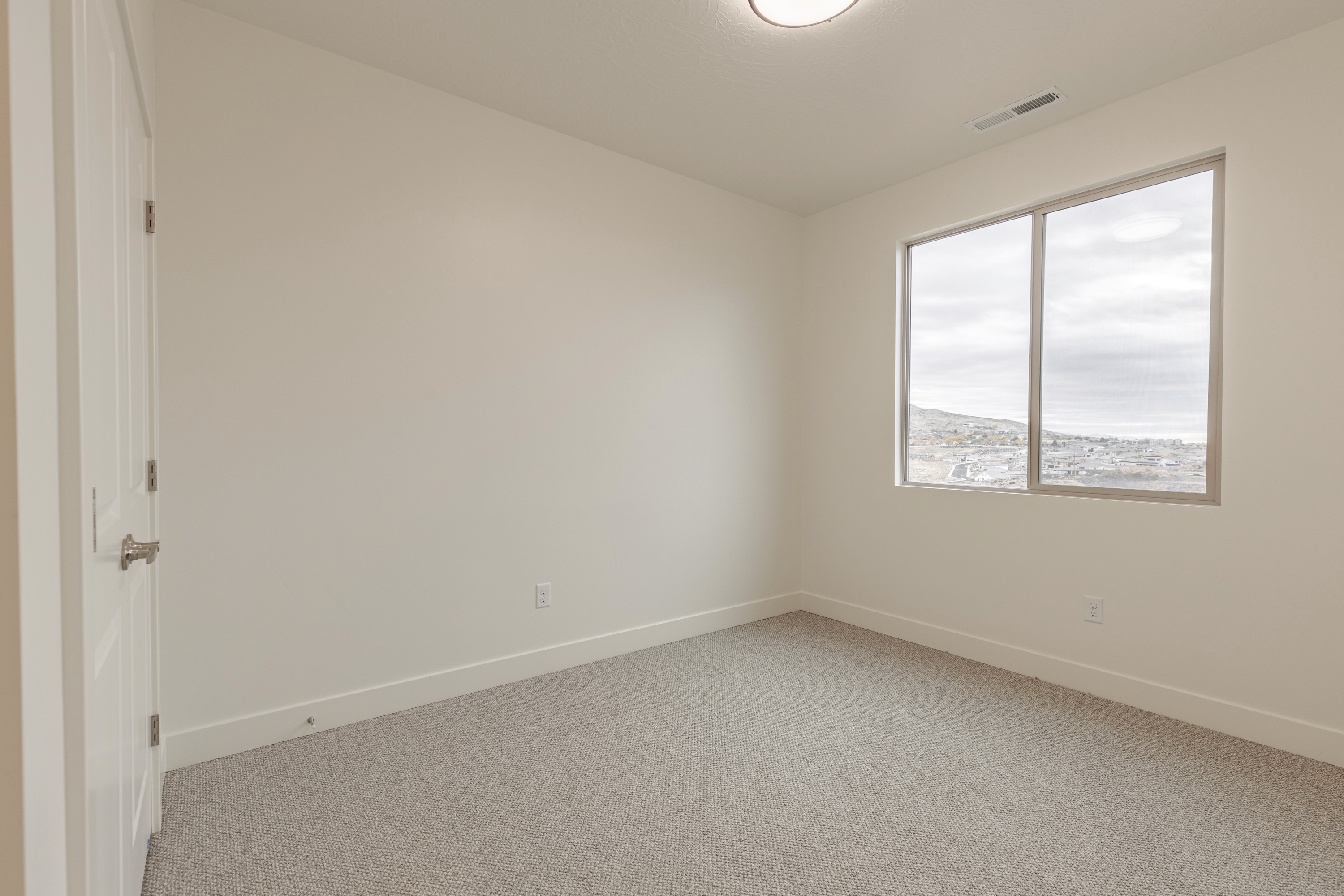 Secondary bedroom in the Painted Sands twin home in Hurricane, Utah with natural light and simple, livable design.