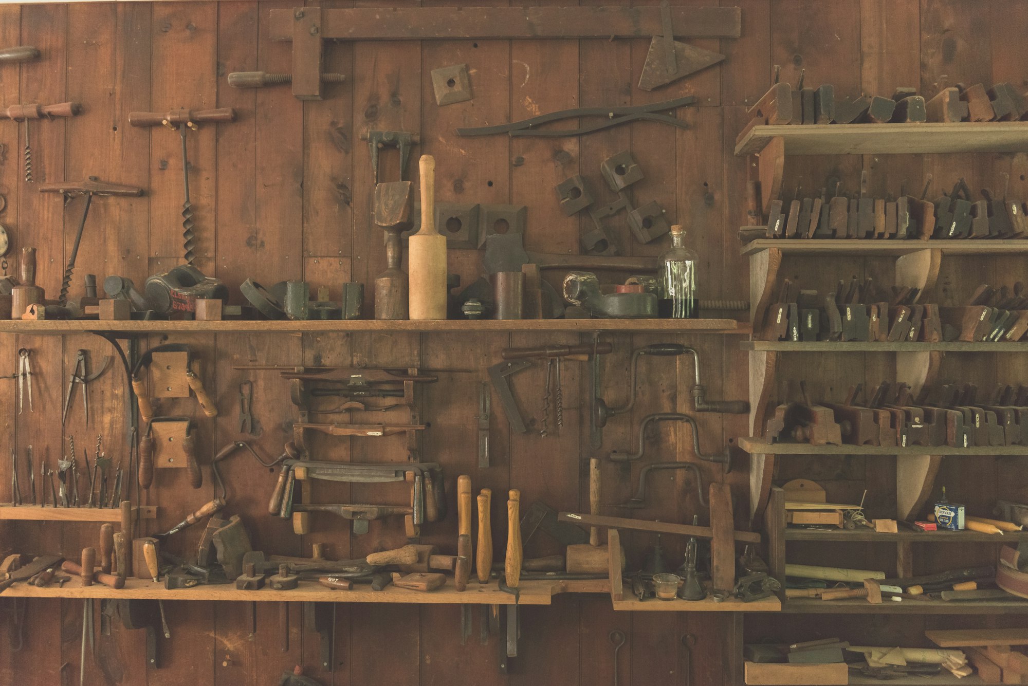 Hand tools on a wooden workshop shelf