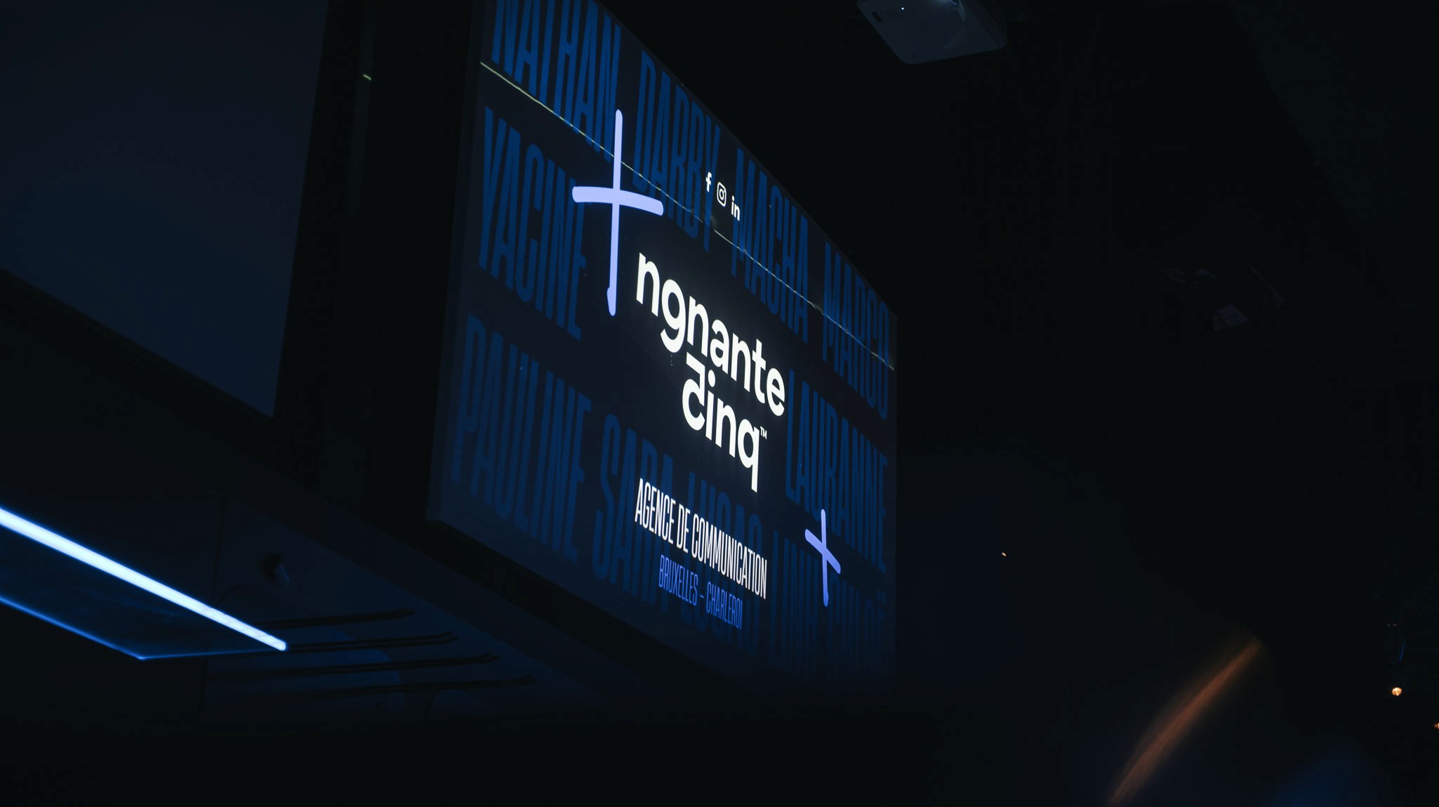 Modern home office setup with a monitor, ergonomic chair, keyboard, and indoor plants near a window with blinds.