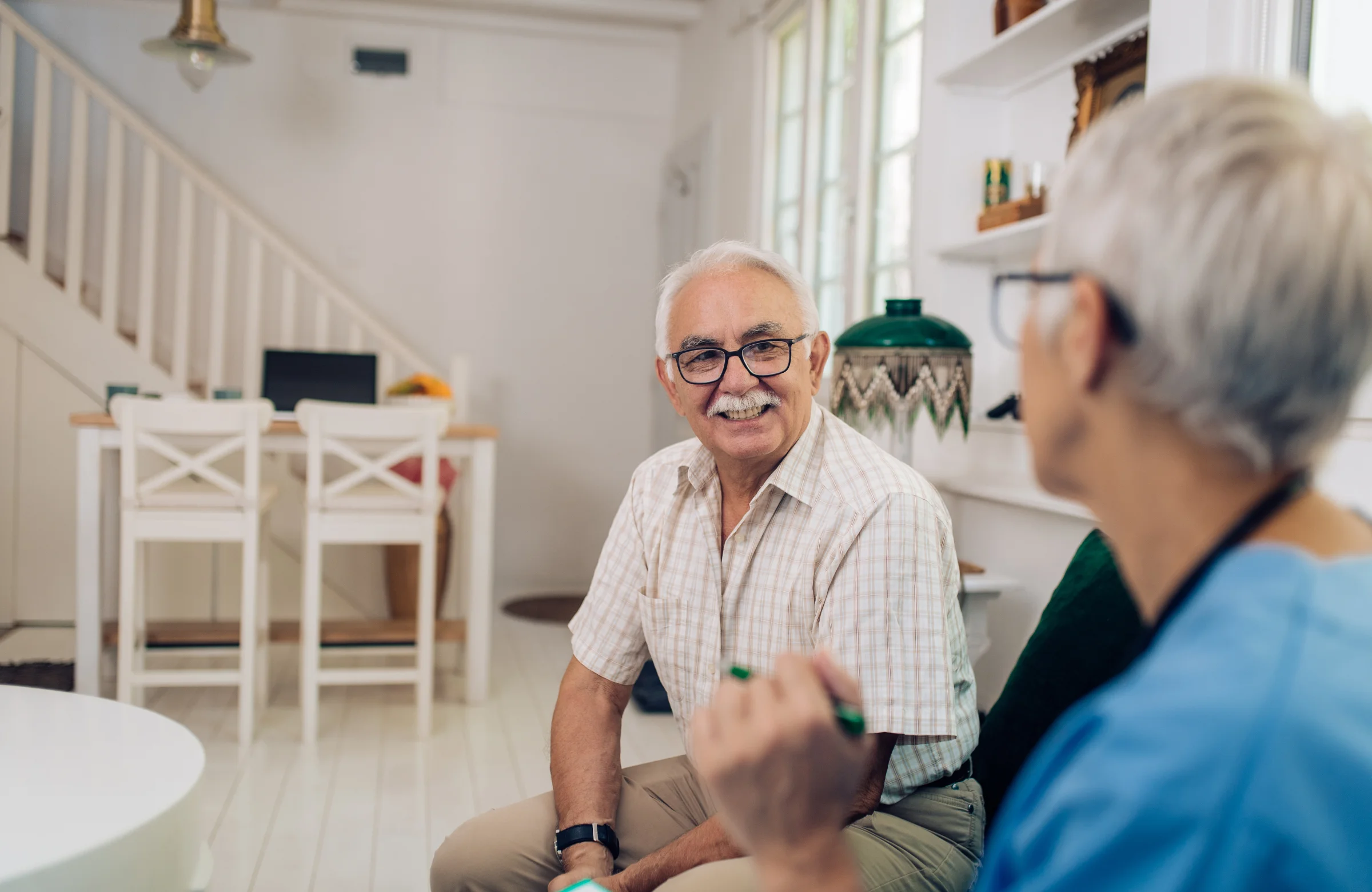 Community nurse discussing bowel health with older client at home in Brisbane
