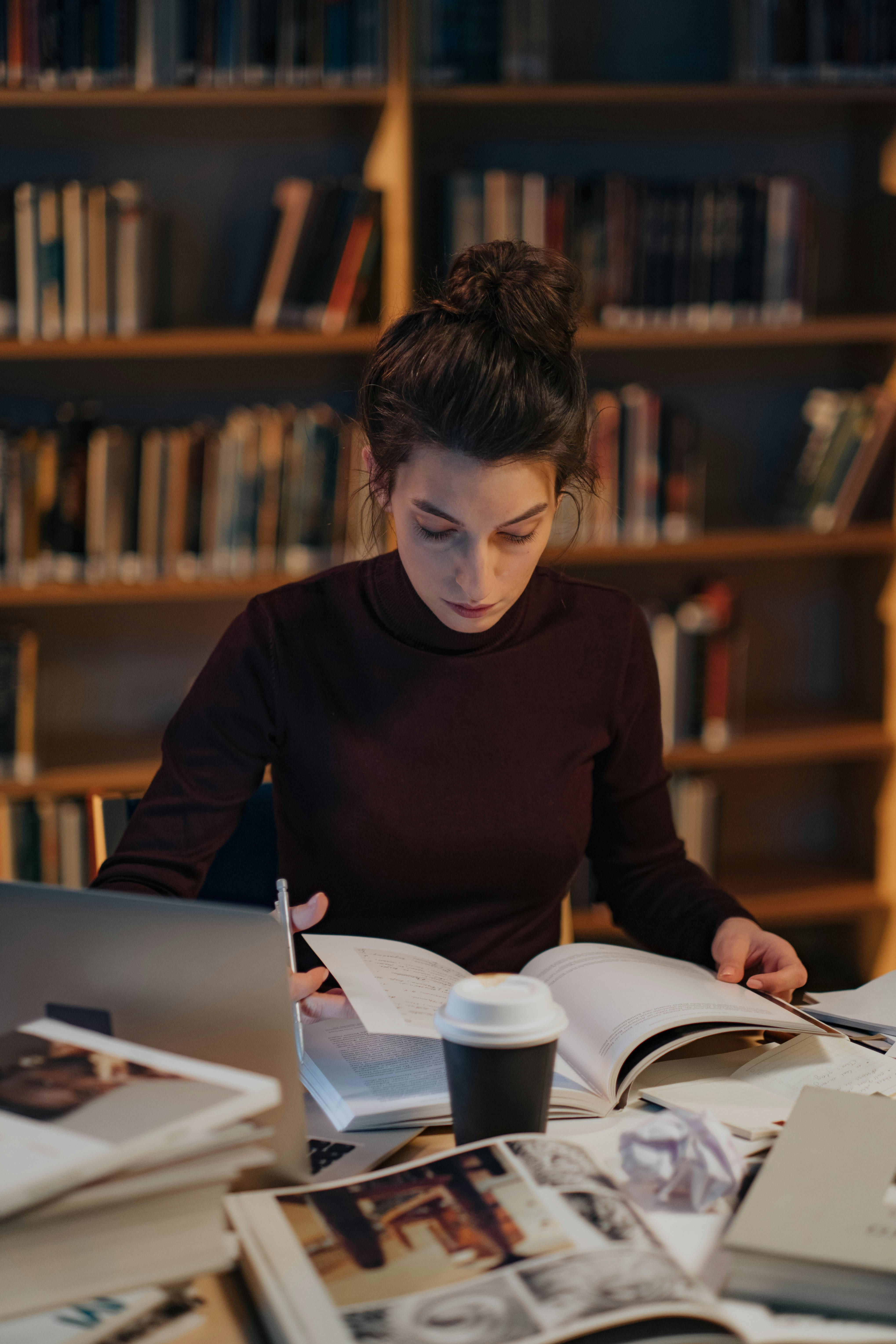 a-woman-intensely-studying-books-in-a-library,-surrounded-by-bookshelves-and-a-l - ron-lach (pexels)