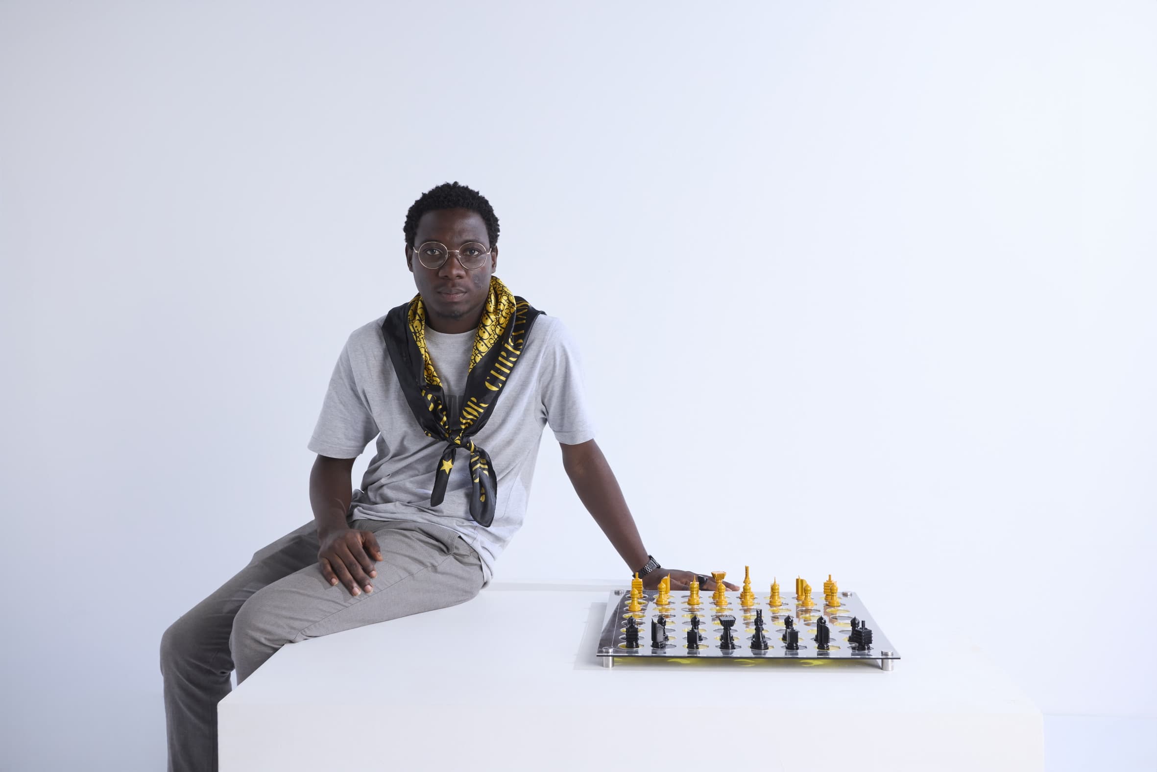Modern home office setup with a monitor, ergonomic chair, keyboard, and indoor plants near a window with blinds.