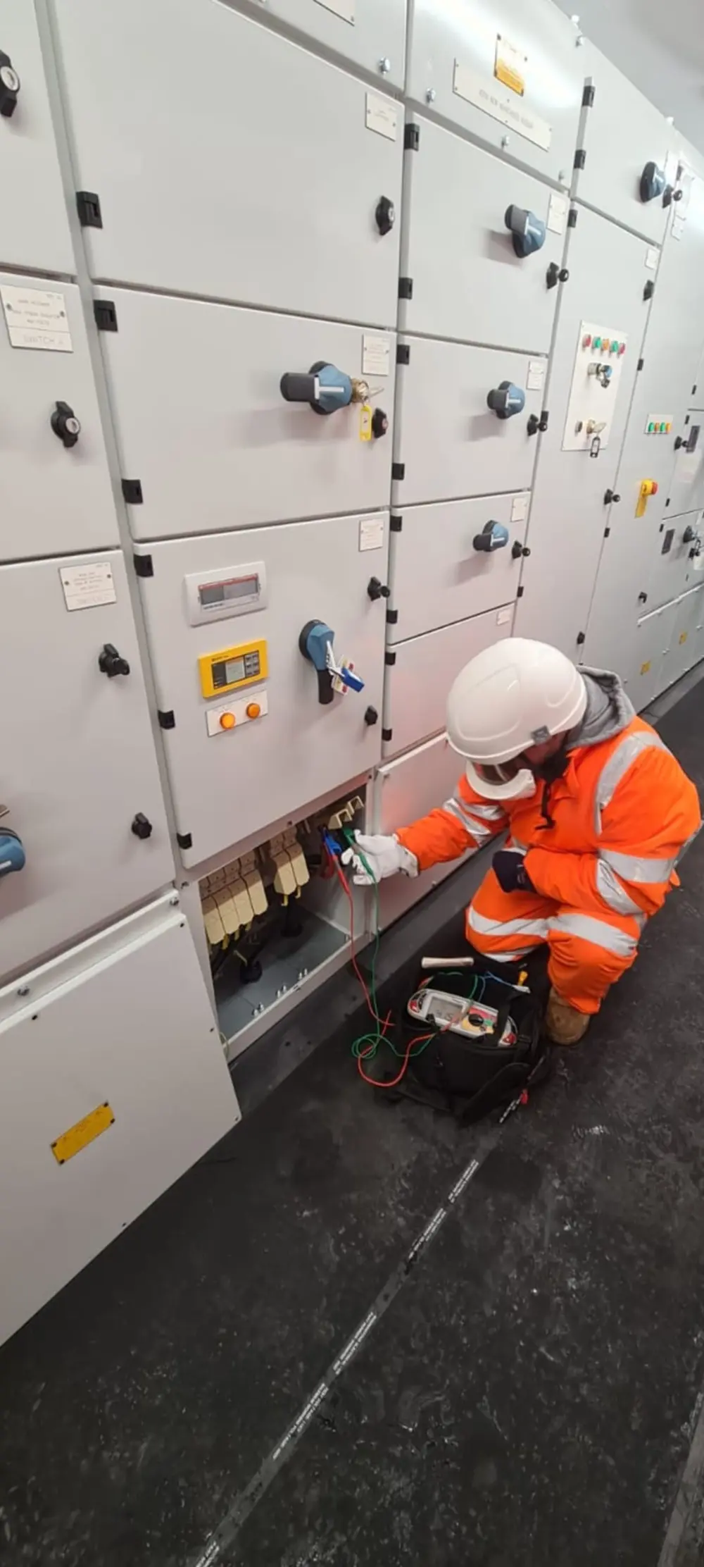 Entrance of a modern glass building with illuminated facade and reflections