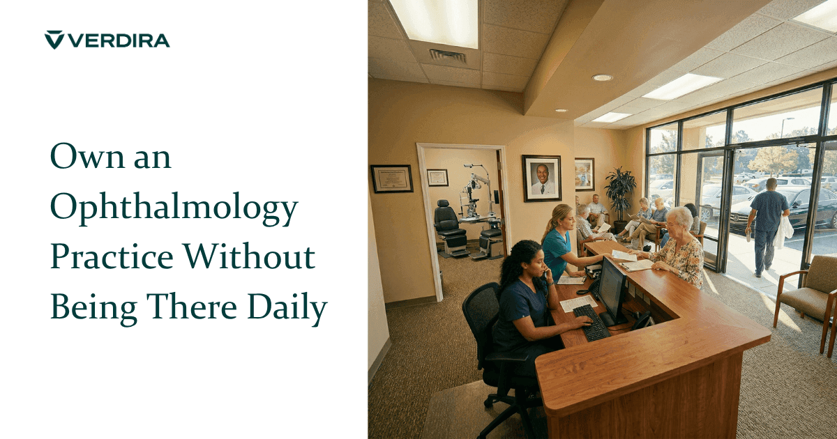 Ophthalmology practice running smoothly with staff at front desk helping patients while physician owner walks out the door with his white coat over his arm and his framed portrait on the wall