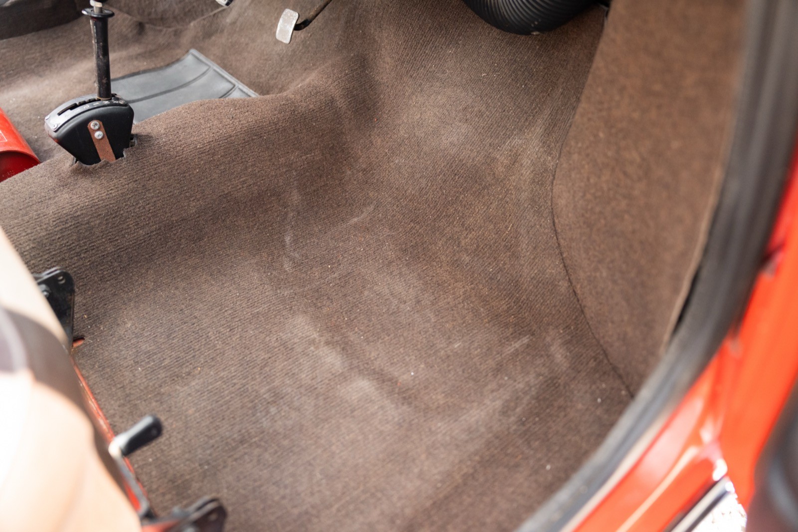 Image of a clean car interior, focusing on the floor mat and carpeting area in a vehicle.