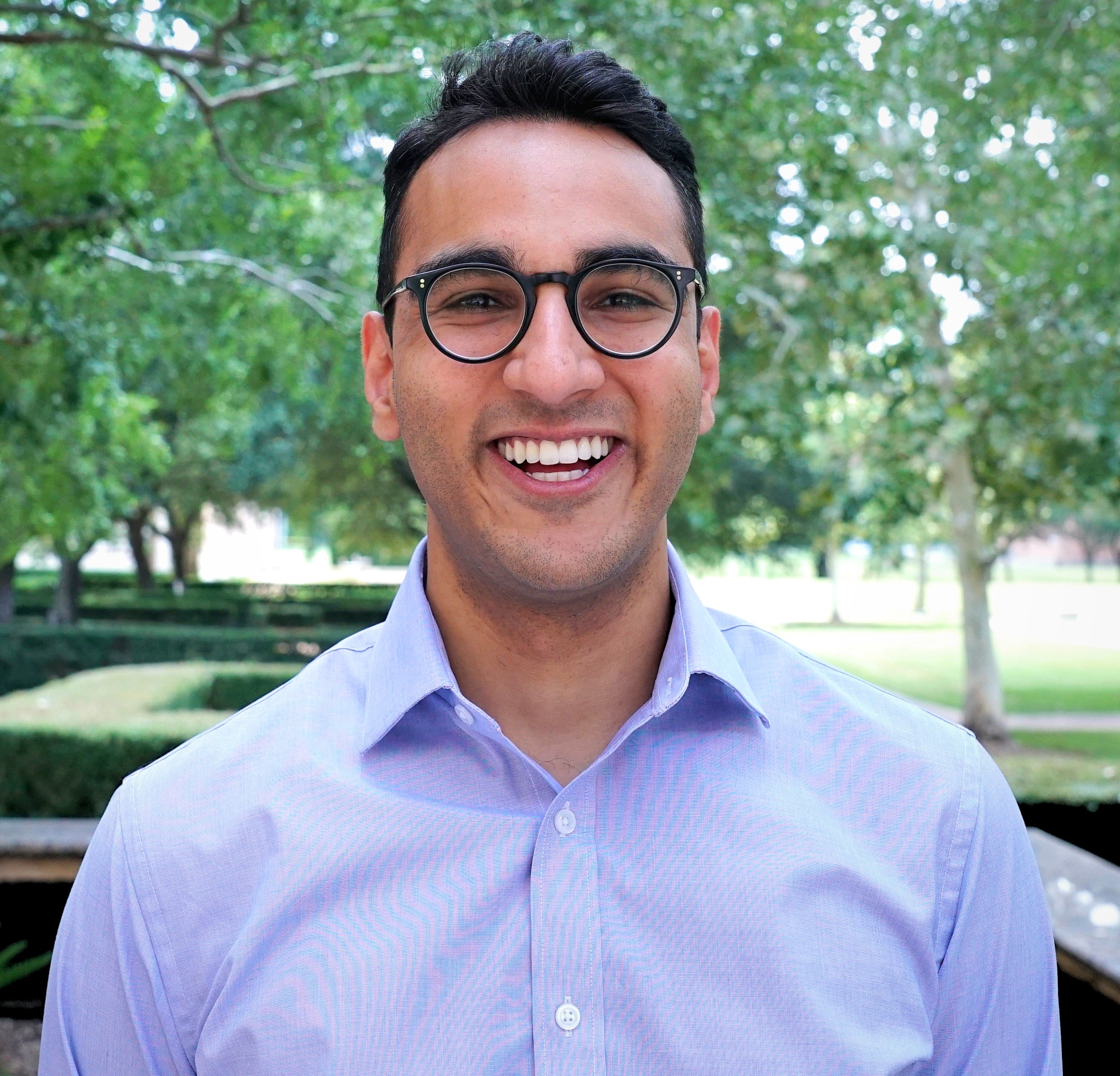 Headshot of a man wearing glasses and smiling. 