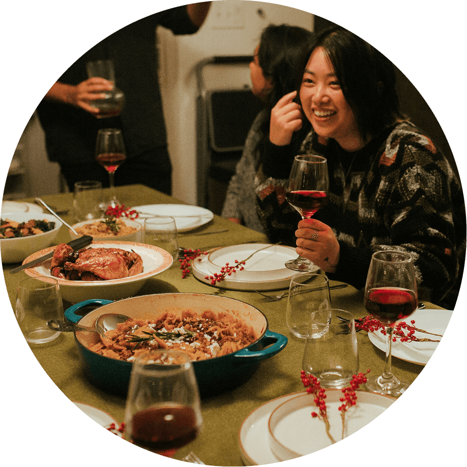 Group of friends gathered around a dining table sharing a meal with dishes