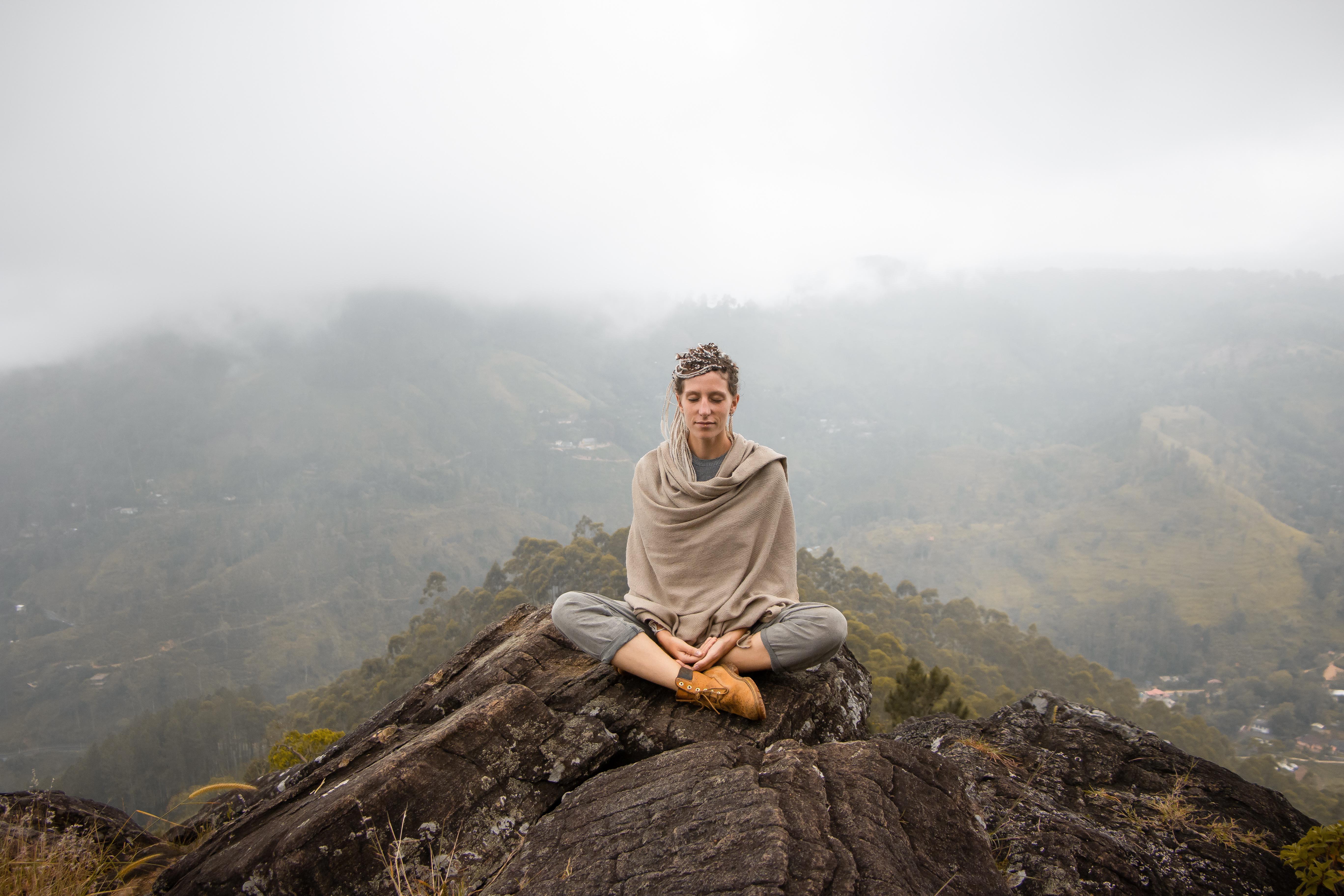 Femme méditant en montagne, séance de pleine conscience. Yoga, bien-être et sérénité.