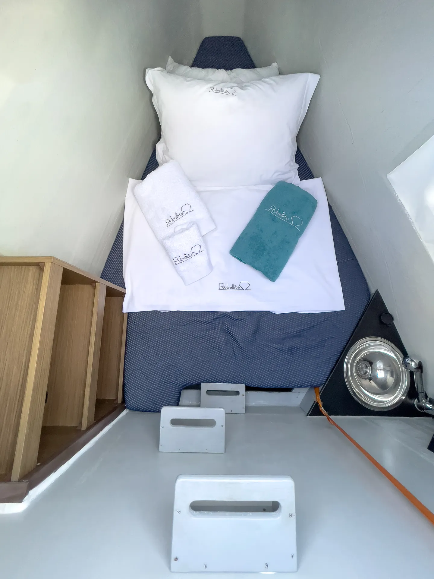 White Rock 36 speedboat with captain at helm cruising calm blue waters near Paros coastline with hills in background.