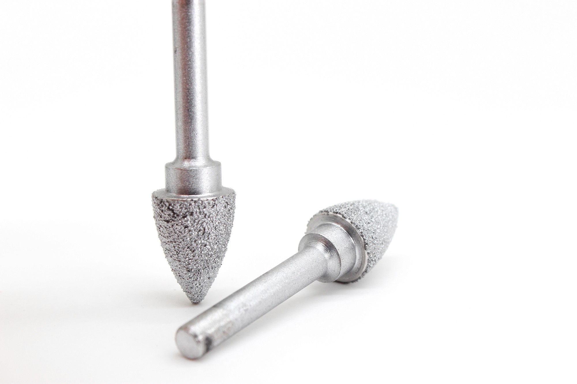 A close-up of two pointed Diamond Carving Bits, focusing on the textured surface designed for detailed carving in granite and marble.