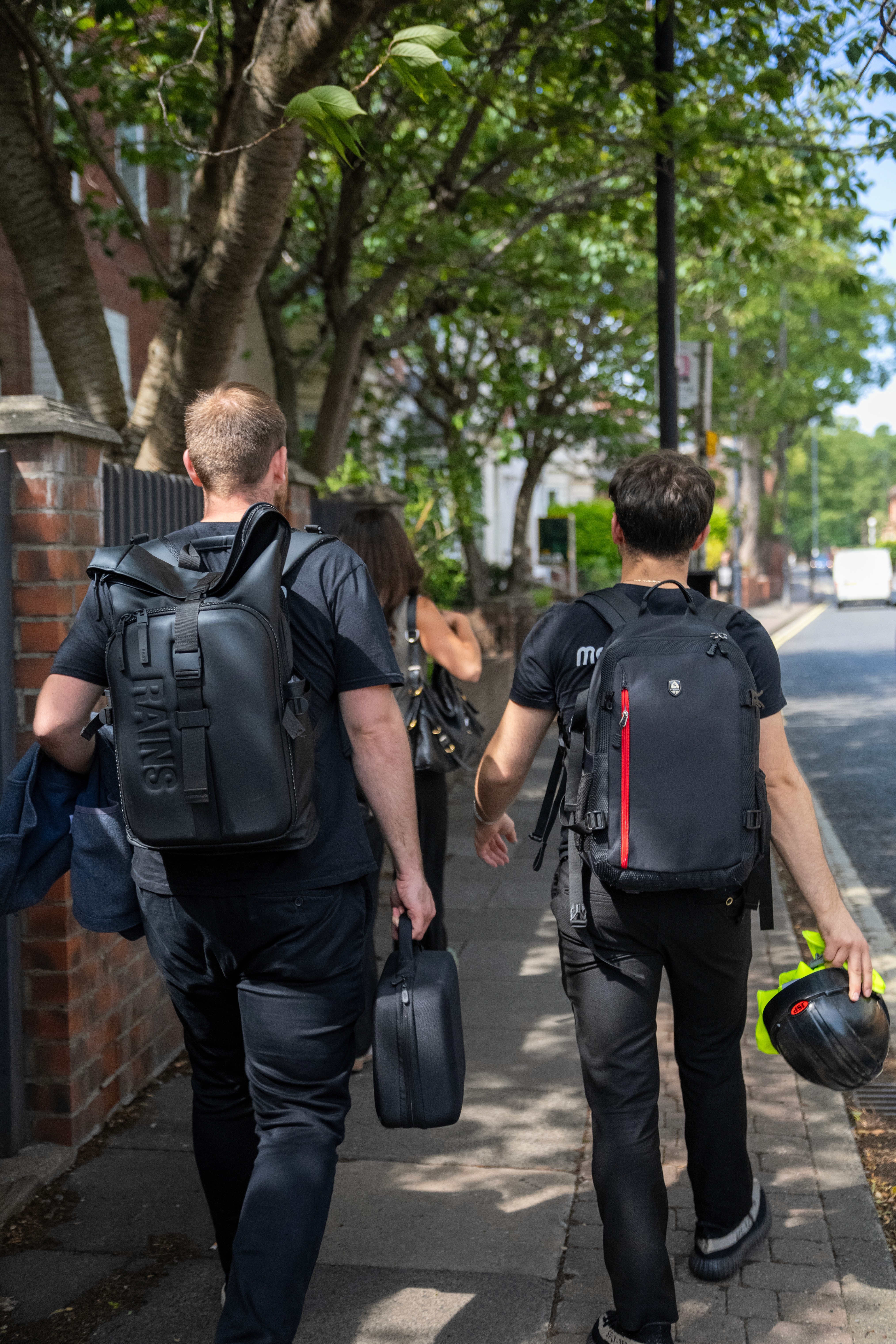 Woman in conical hat rides bicycle down street.