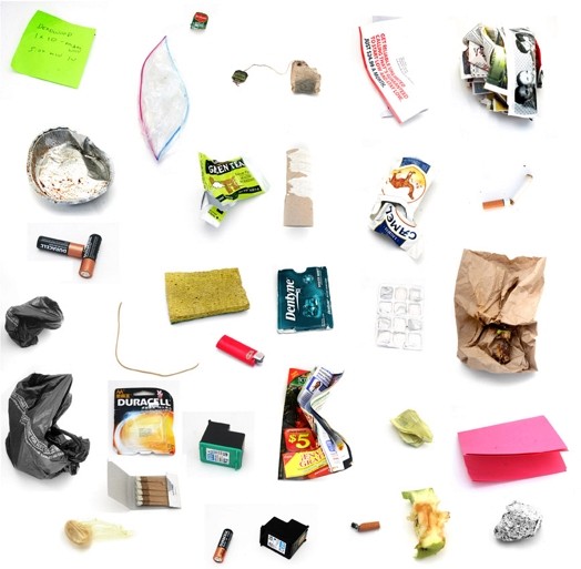 A picture of different objects post-it stickers, batteries, matches, twisted empty cigarette box, empty blister, lighter, apple remain, printing cartridge, sponge, empty toilet paper roller, and other objects.