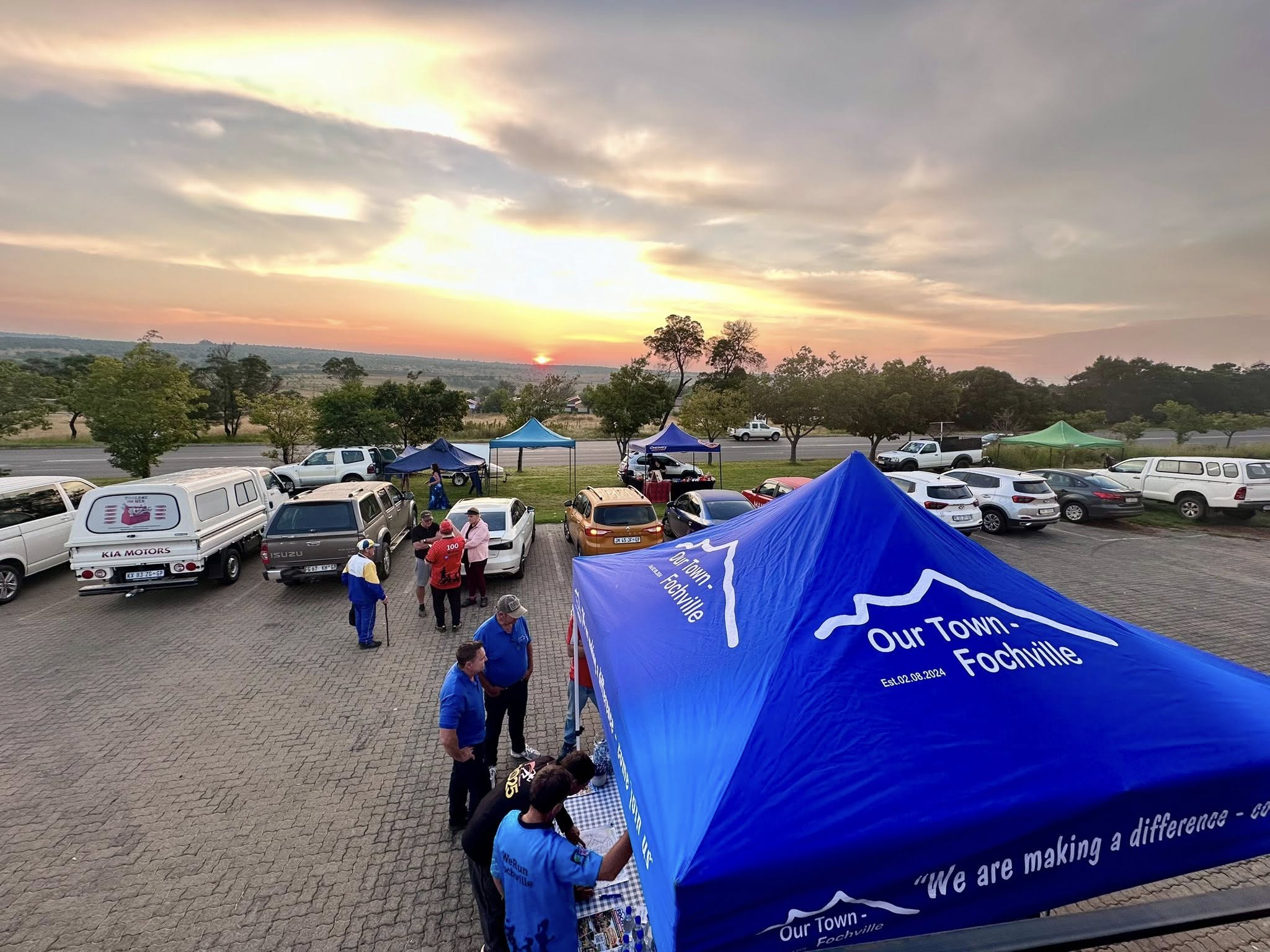 four boys laughing and sitting on grass during daytime