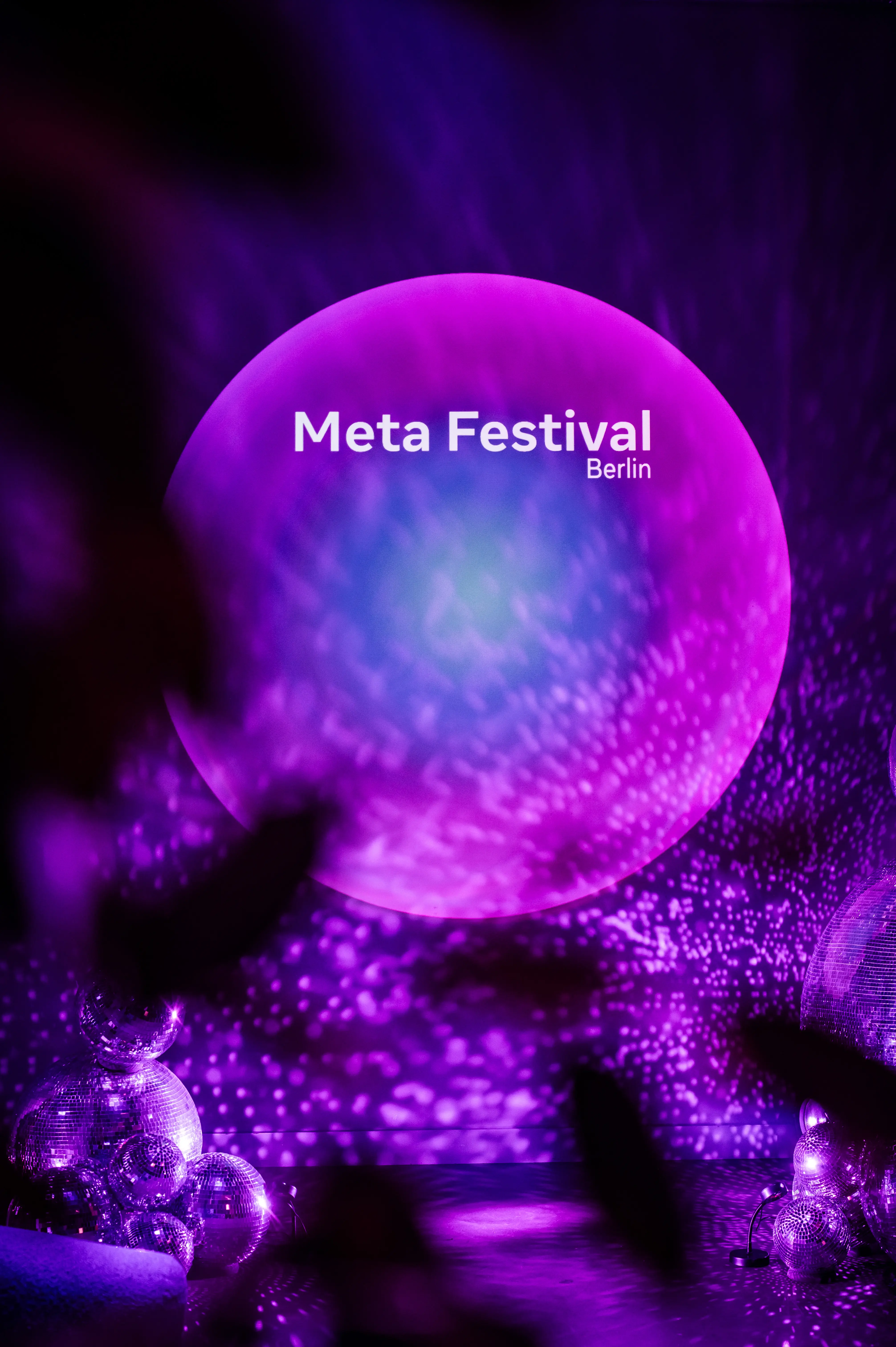Glowing Meta Festival Berlin sphere in purple light with sparkling reflections.