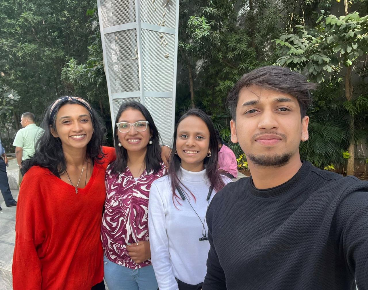 Green chair at desk with artwork and flowers.