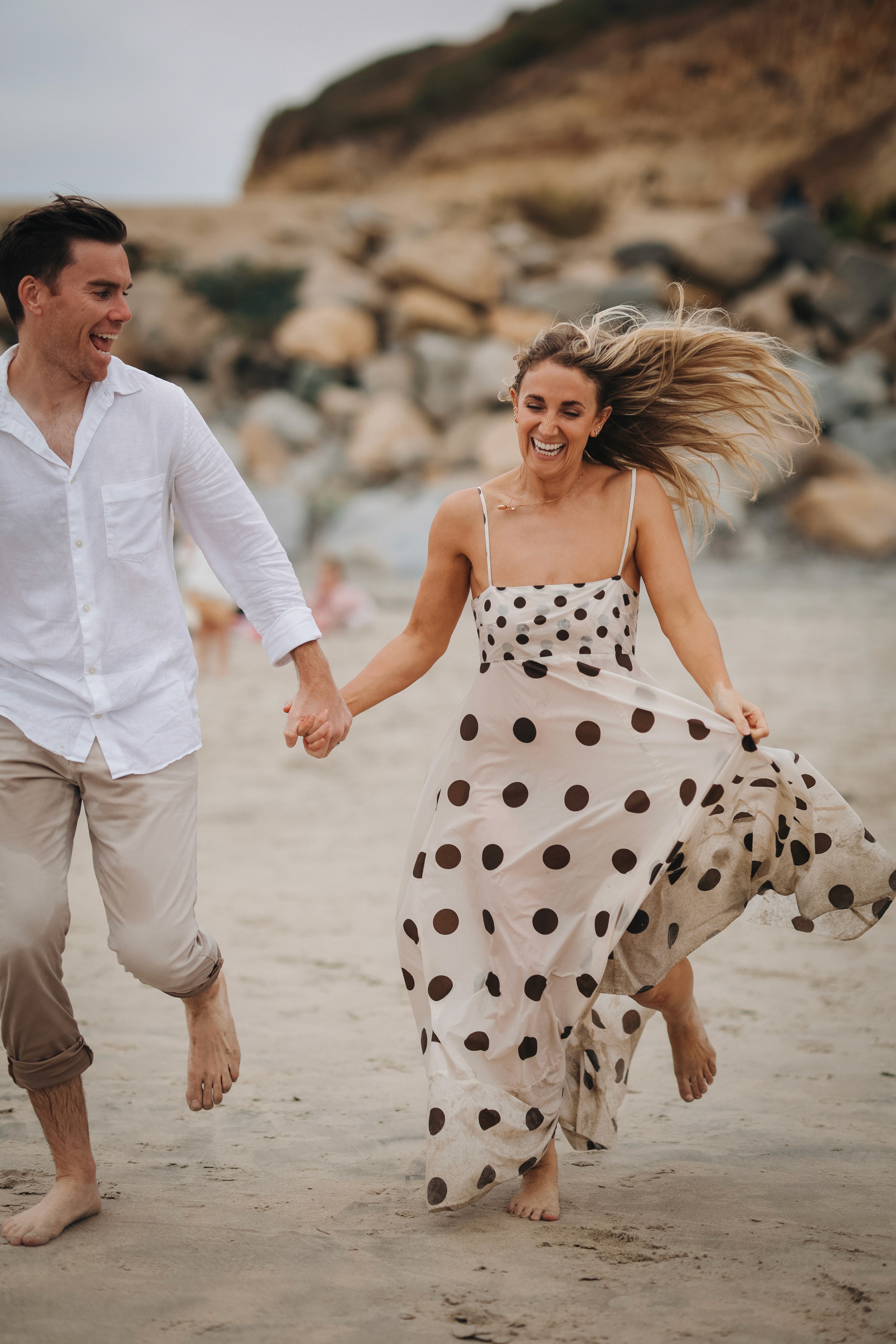 Parents walking hand in hand along the San Diego beach during a lifestyle shoot