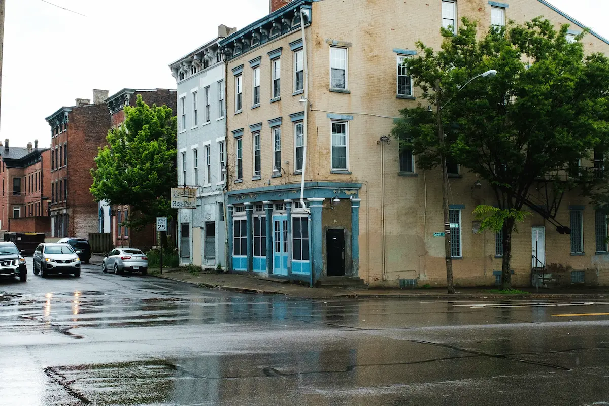 Rainy street intersection with older buildings on a quiet city block