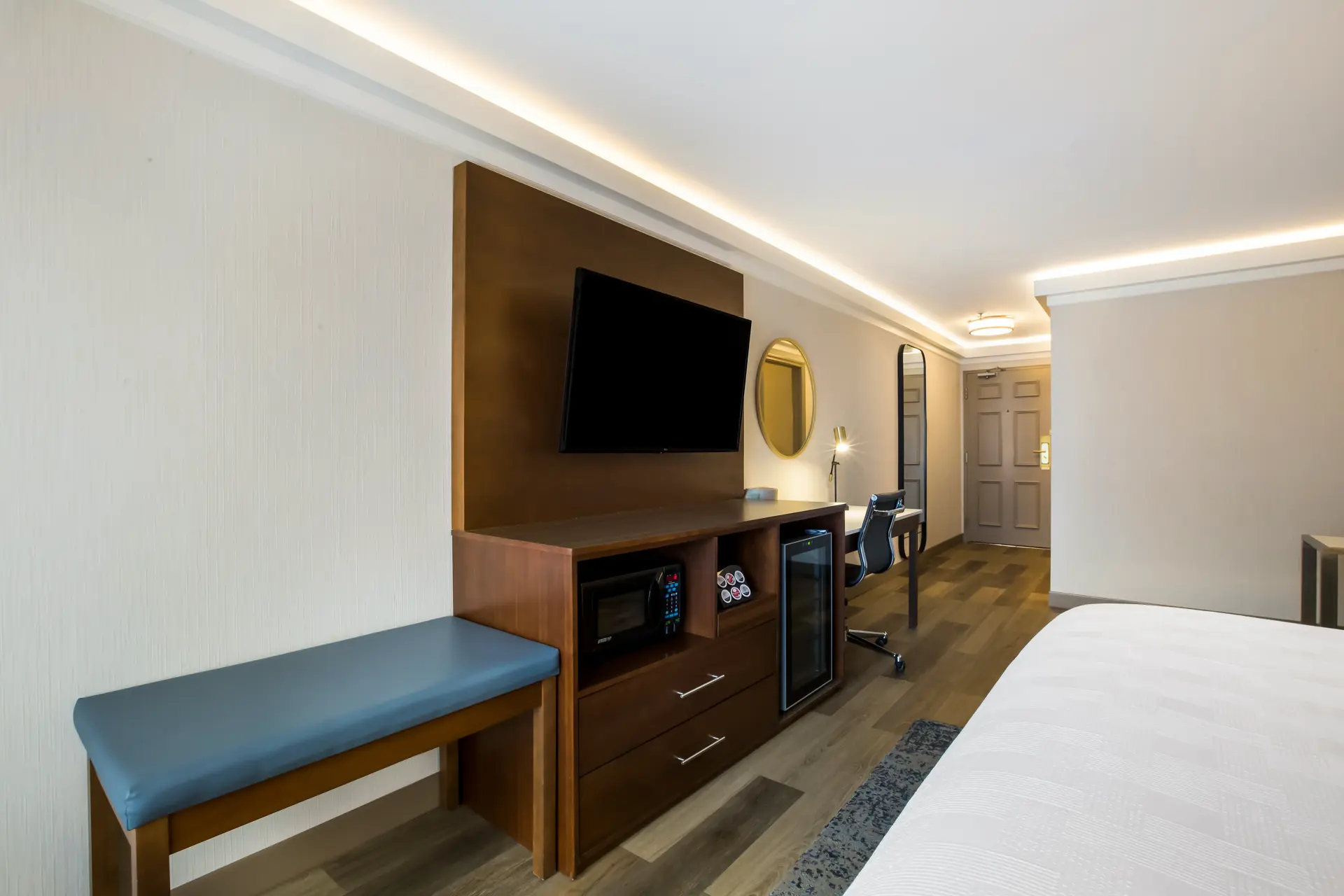 Bright modern hotel room with two beds and a desk.