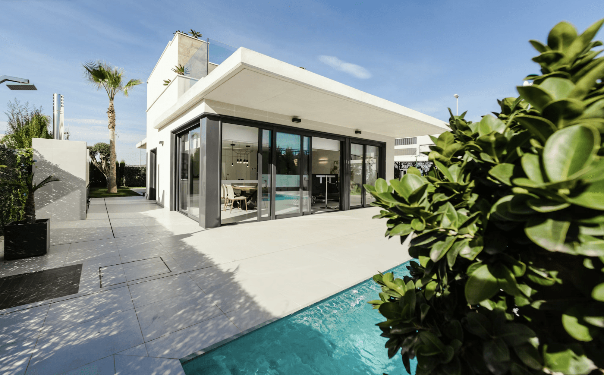 A quaint house surrounded by colorful flowers under a soft, muted sky with distant trees in the background.