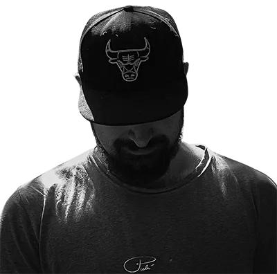 Silhouette portrait of Lucas Ostrowski, automation expert and Acutus Digital founder. Wearing a Chicago Bulls cap, face partially obscured, creating an air of focus and determination. Black and white image symbolizes his no-nonsense approach to B2B automation and AI solutions.