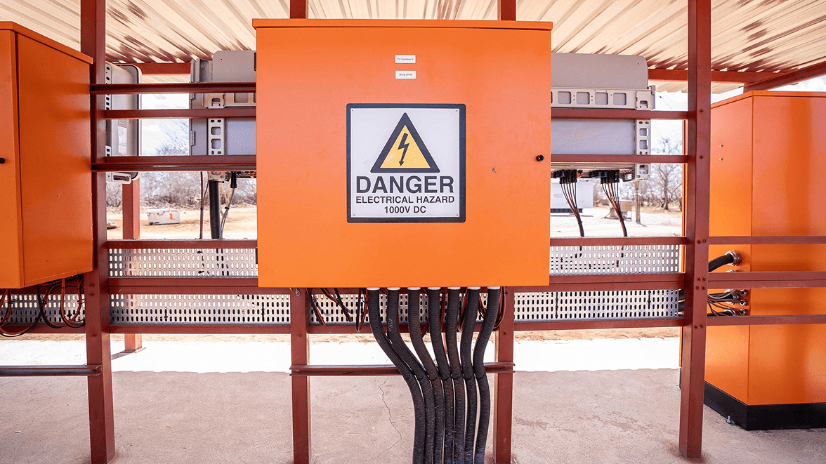 A man and a woman, both in business attire, are engaged in a serious discussion at a table with documents. The setting conveys a professional tone.