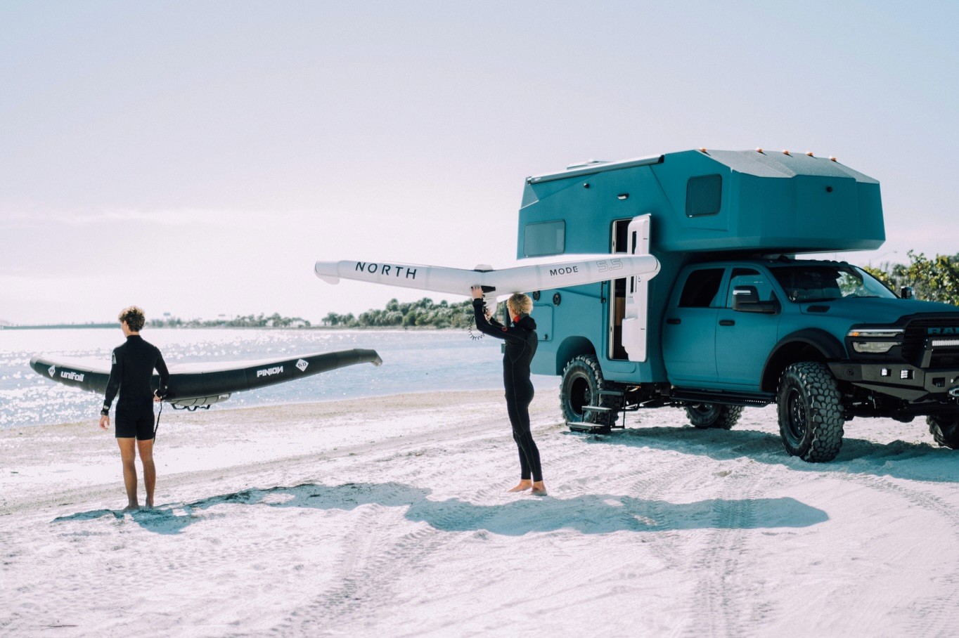 27North adventure vehicle on the beach with 2 wingers staring at the water