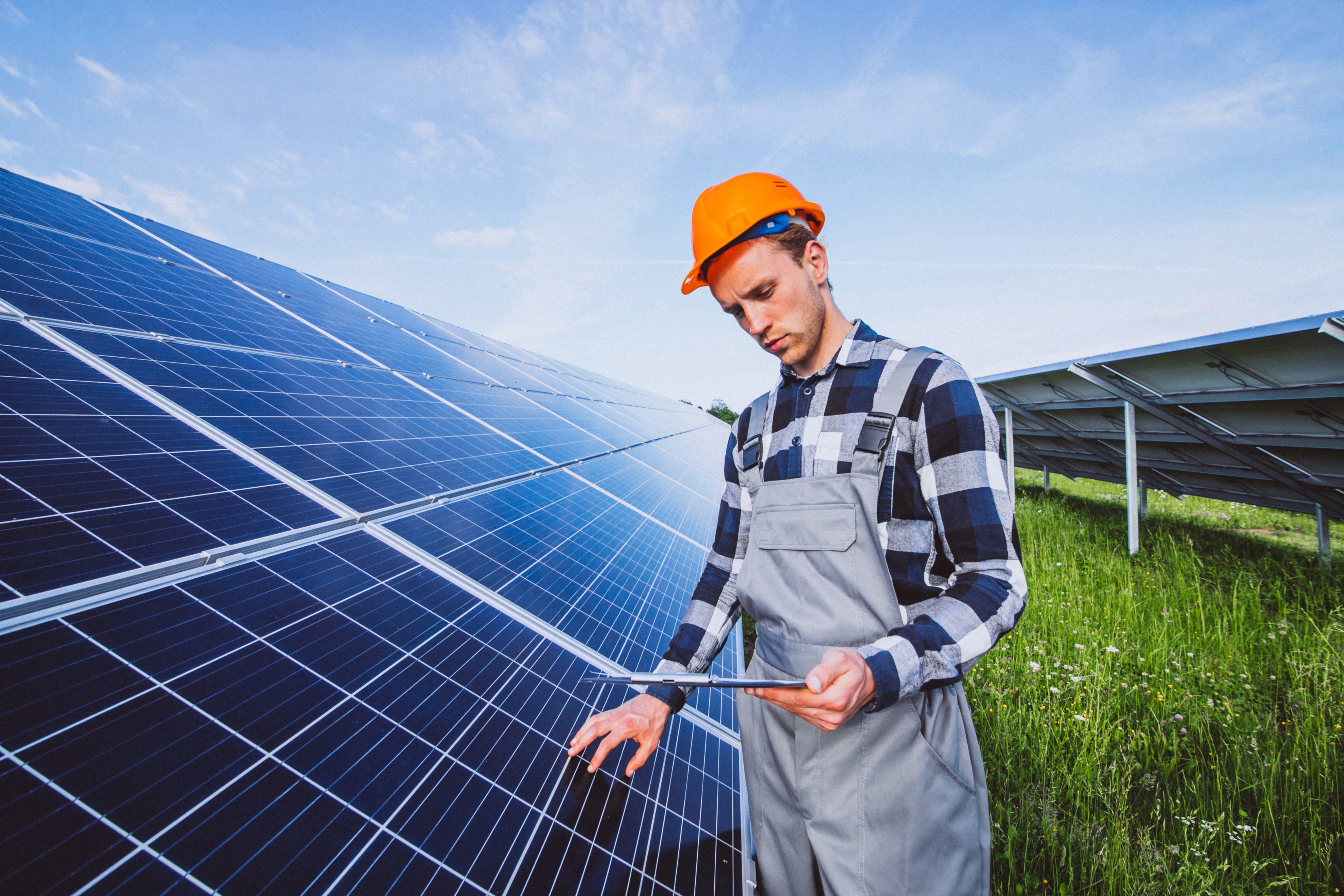 Technician with tablet inspecting solar panels