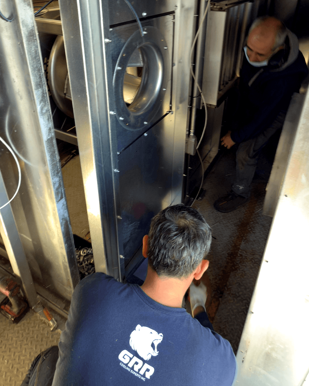 GRR Cooling Experts technician installing a new EC fan module inside a hospital air handling unit during retrofit commissioning.