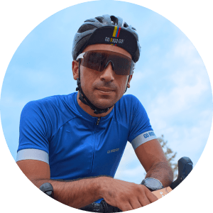 Cyclist in blue jersey with sunglasses and helmet.