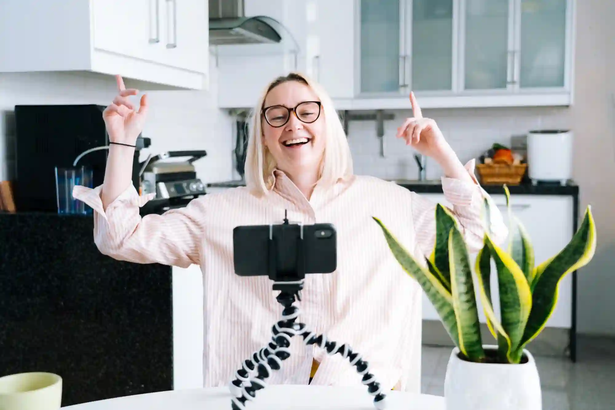 Woman happily live streaming on phone tripod.