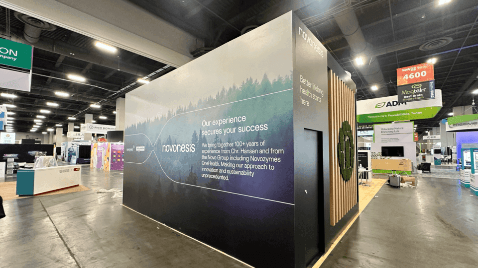 Tea and beverage booth with tasting counter, packaging display, branded graphics, storage, and buyer conversation area