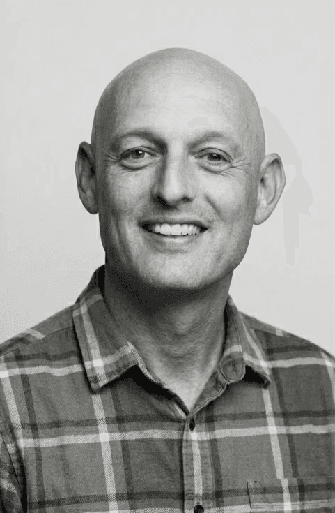 Portrait of a man with blue eyes and a beard, wearing a denim shirt