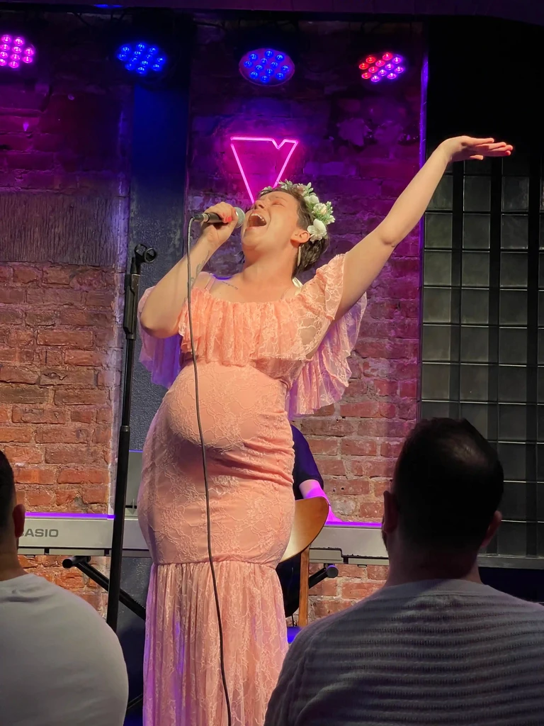A performer stretches one arm overhead during a solo