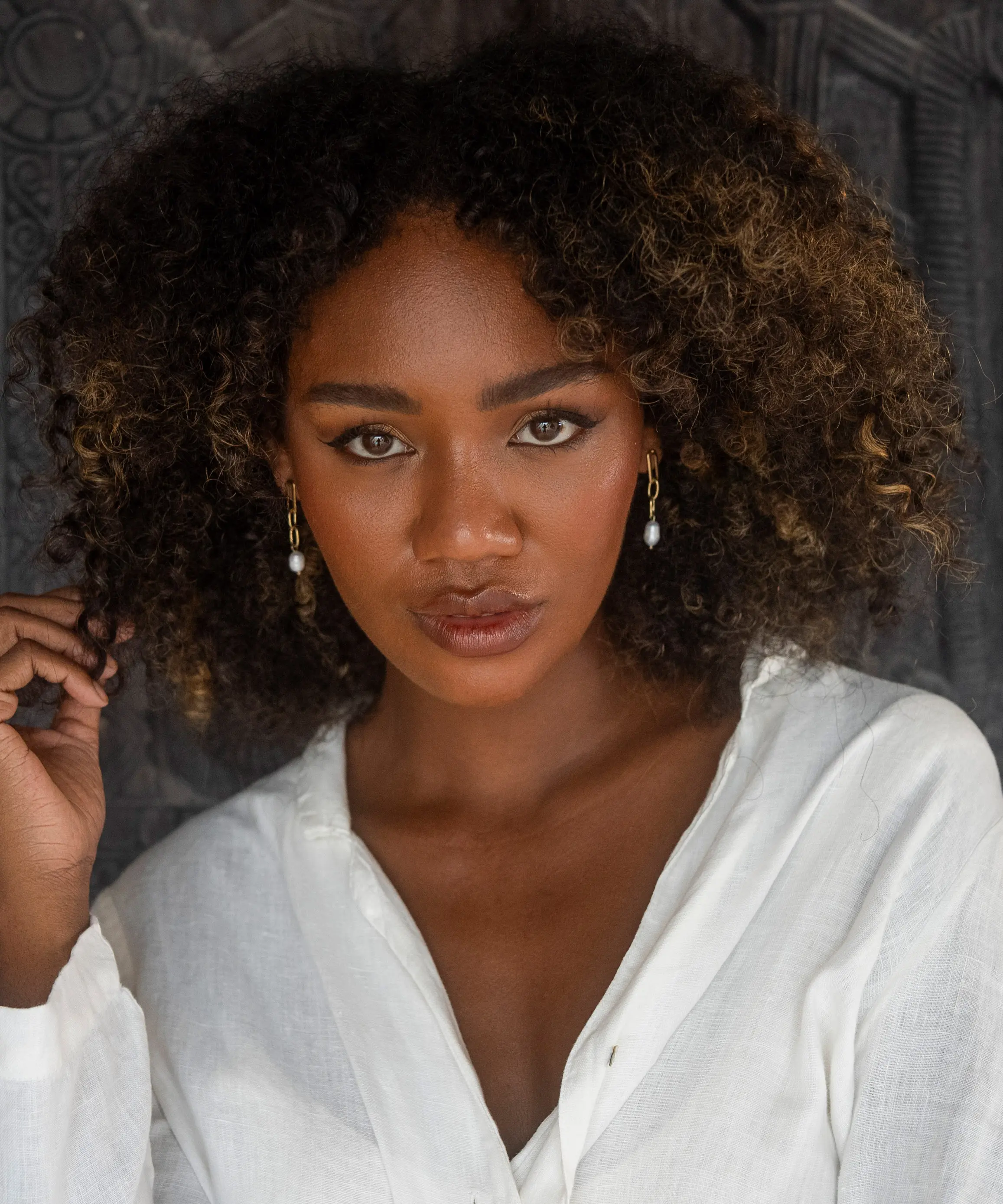 golden earring worn by curly hair model