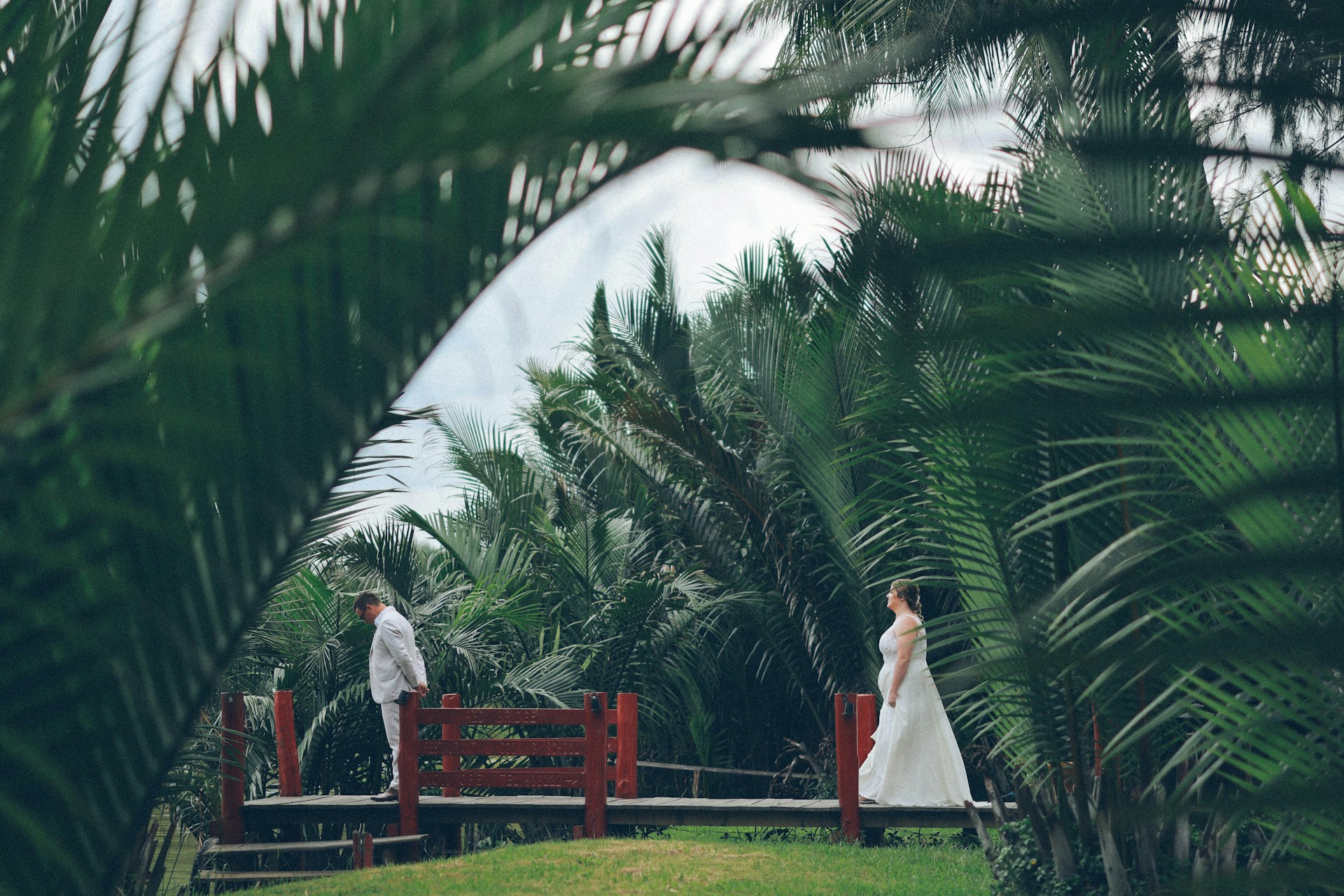 wedding ceremony with bride and groom between palm trees
