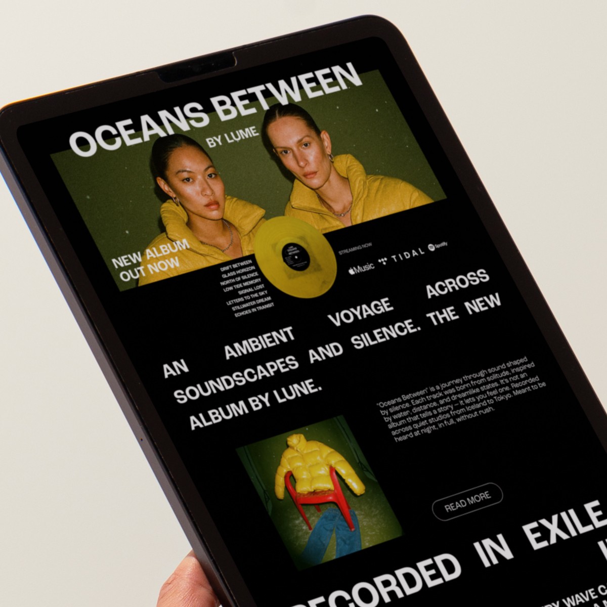 man wearing grey t-shirt standing in front of man sitting on chair