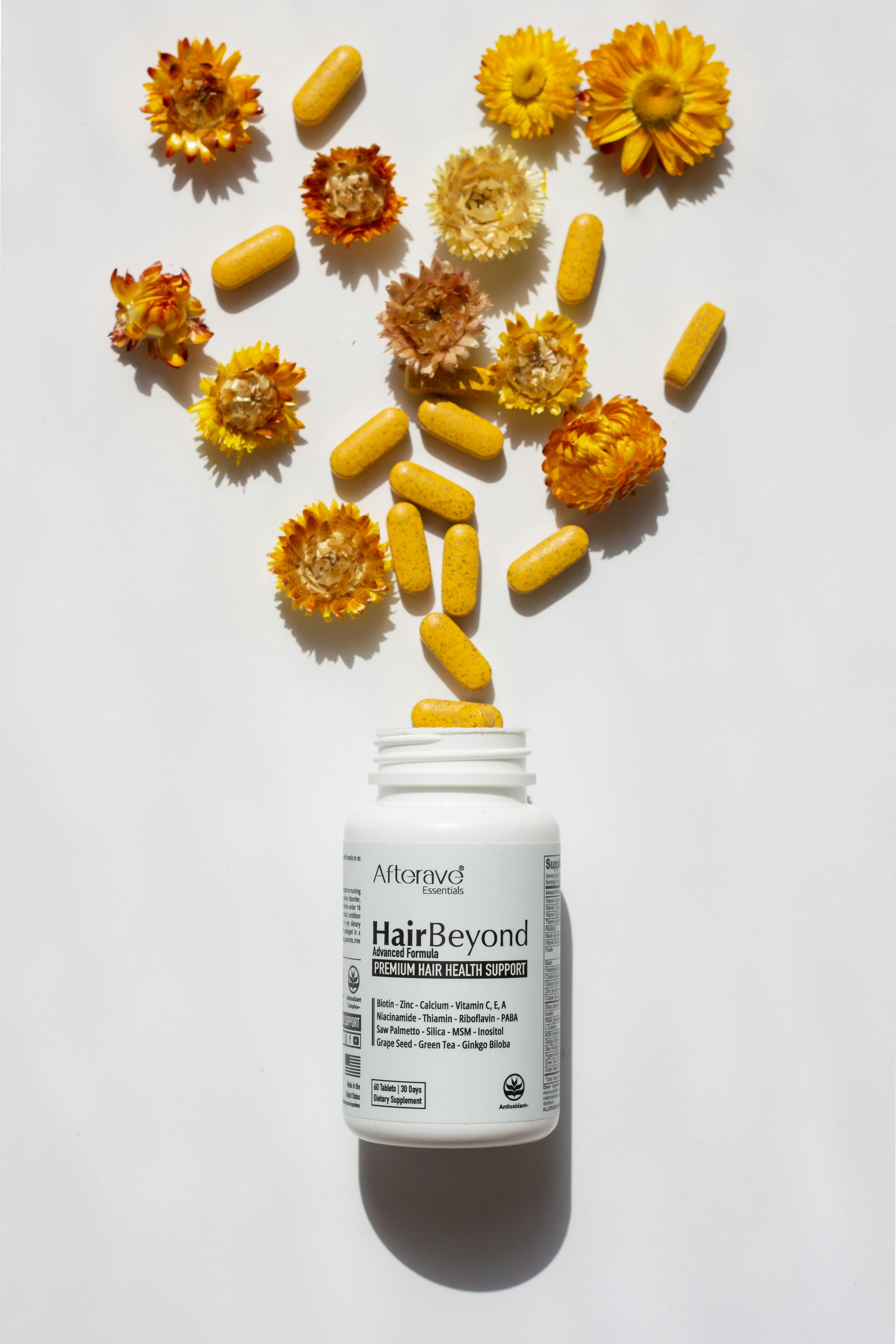 hairbeyond-supplement-bottle-surrounded-by-flowers-and-pills-emphasizing-hair-he - afterave-essentials (pexels)
