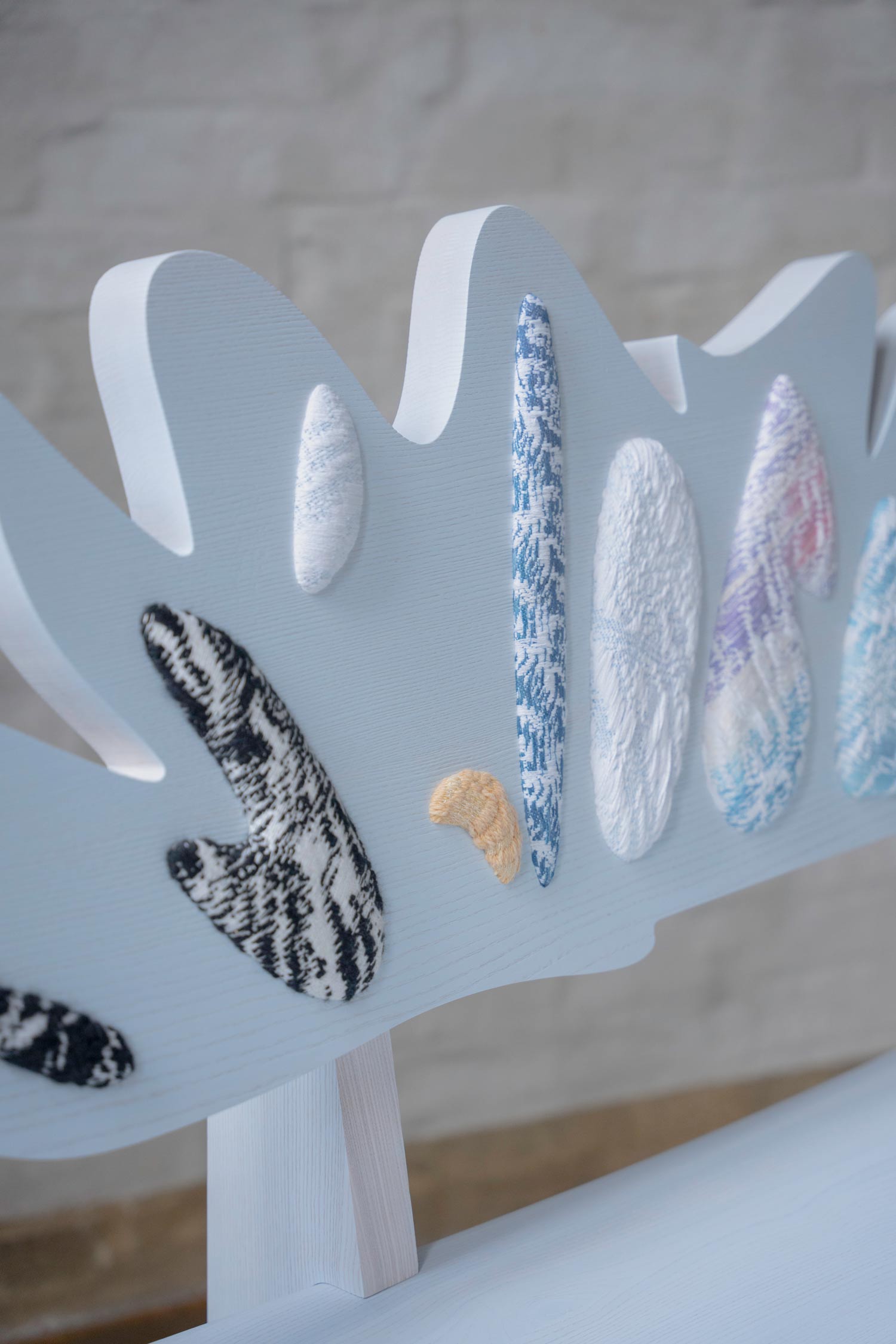 Close-up of Cloudy Preludium bench showing hand woven textile detail and wooden surface texture by Jiri Krejcirik